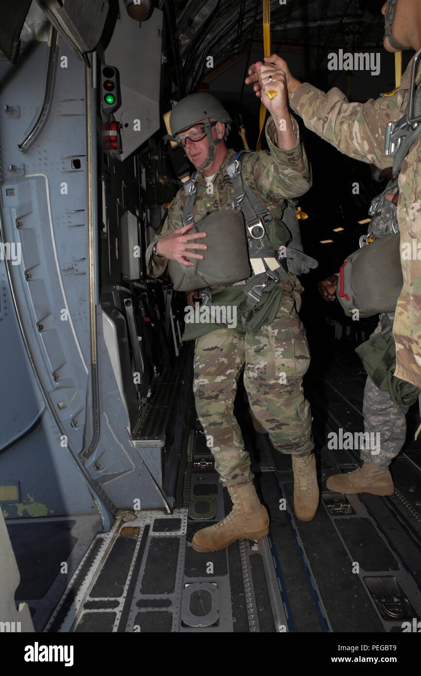 U.S. Army Maj. Christopher Murphy, commander of the 982nd Combat Camera Company, East Point, Ga., hands off his static line as he exits a C-17 Globemaster III aircraft during the 75th Anniversary of Airborne School jump, at Fort Benning, Ga., Aug. 15, 2015. The 1-507th Parachute Infantry Regiment (PIR) Battalion celebrates 75 years of the U.S. Army Airborne School and the commemoration of the last qualifying jump of the first airborne test platoon on Aug. 15, 1940. (U.S. Army Photo by Spc. Joshua Talley/ Released) Stock Photo