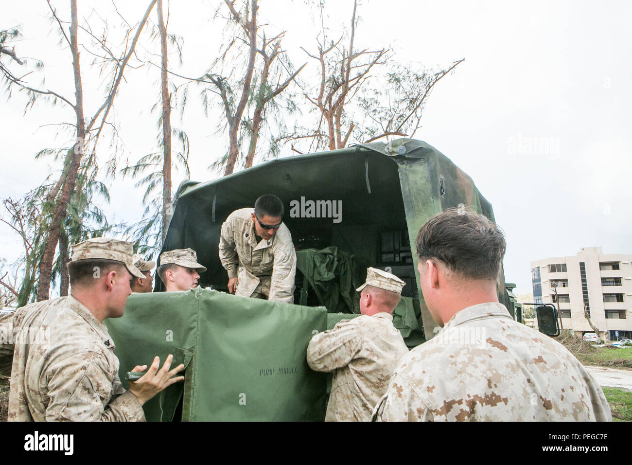 U.S. Marines from Combat Logistics Battalion 31, 31st Marine Expeditionary Unit, unload a Light Weight Purification System from a Humvee in Saipan, Aug 10, 2015. The 31st MEU and the ships of the Bonhomme Richard Amphibious Ready Group are assisting federal and local agencies with distributing emergency relief supplies to Saipan after it was struck by Typhoon Soudelor, Aug. 2-3. (U.S. Marine Corps photo by Lance Cpl. Brian Bekkala/Released) Stock Photo