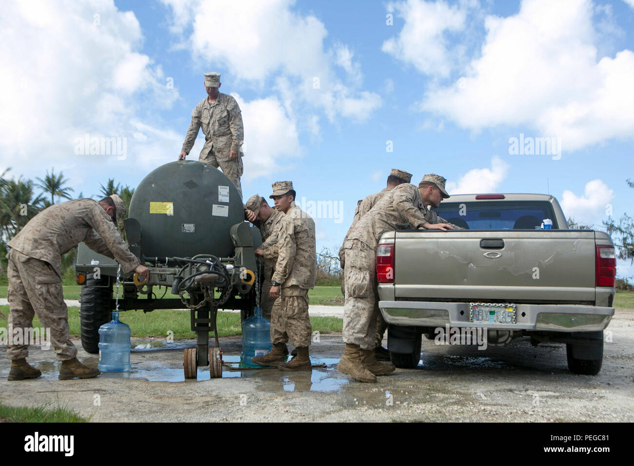 U.S. Marines with Combat Logistics Battalion 31, 31st Marine Expeditionary Unit, distribute water to local civilians as part of typhoon relief efforts in Saipan, Aug. 11, 2015. The 31st MEU and the ships of the Bonhomme Richard Amphibious Ready Group are assisting the Federal Emergency Management Agency with distributing emergency relief supplies to Saipan after the island was struck by Typhoon Soudelor, Aug. 2-3. (U.S. Marine Corps photo by Lance Cpl. Brian Bekkala/Released.) Stock Photo