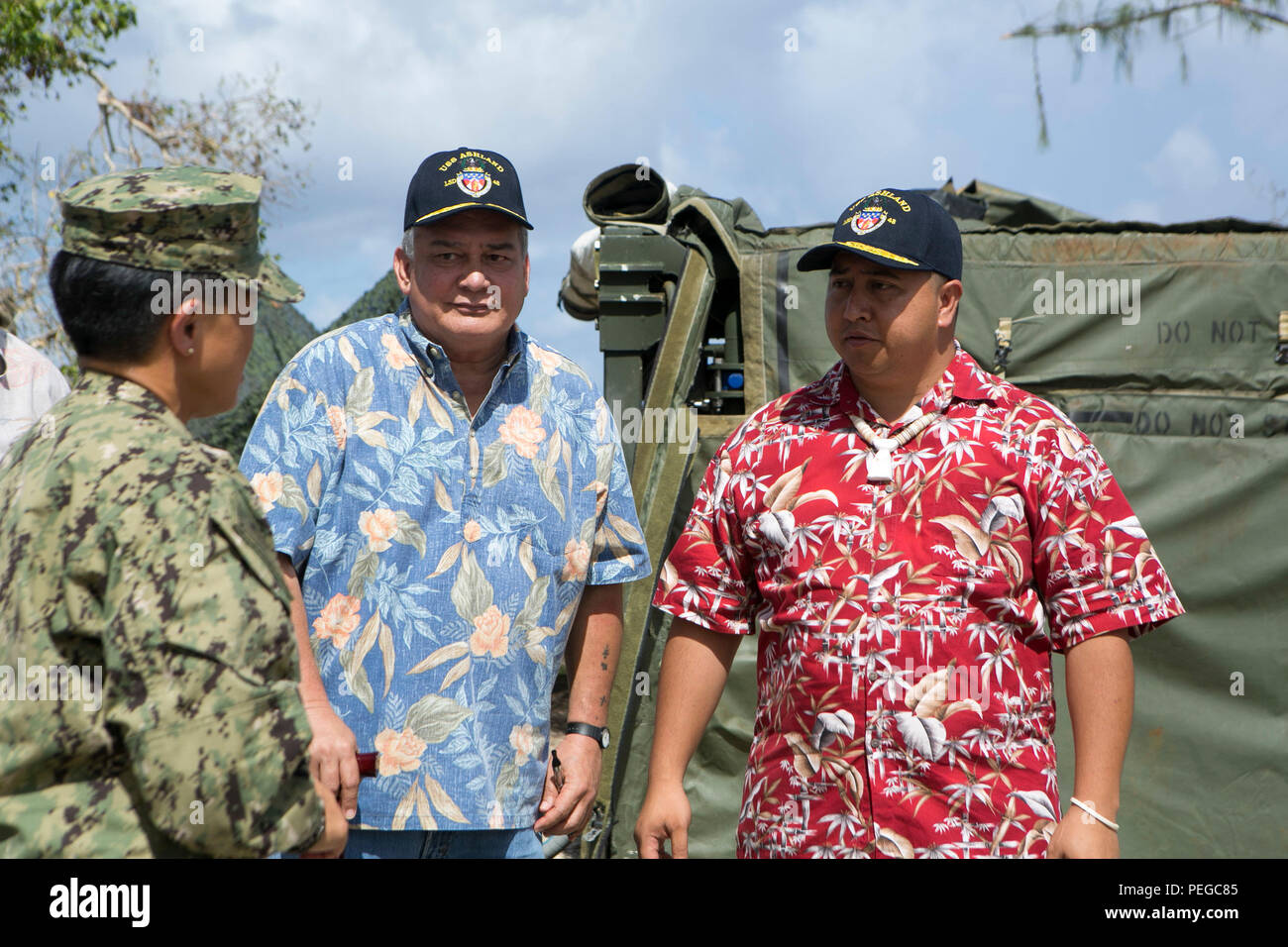 U.S. Navy Rear Adm. Bette Bolivar, commander of U.S. Naval Forces Marianas, speaks with U.S. Congressman Gregorio Kilili Camacho Sablan and Lieutenant Governor Ralph Torres as they tour a water purification site in Saipan, Aug. 11, 2015. The water purification site was set up by the Marines of Combat Logistics Battalion 31, 31st Marine Expeditionary Unit, as part of typhoon relief efforts. The 31st MEU and the ships of the Bonhomme Richard Amphibious Ready Group are assisting the Federal Emergency Management Agency with distributing emergency relief supplies to Saipan after the island was stru Stock Photo