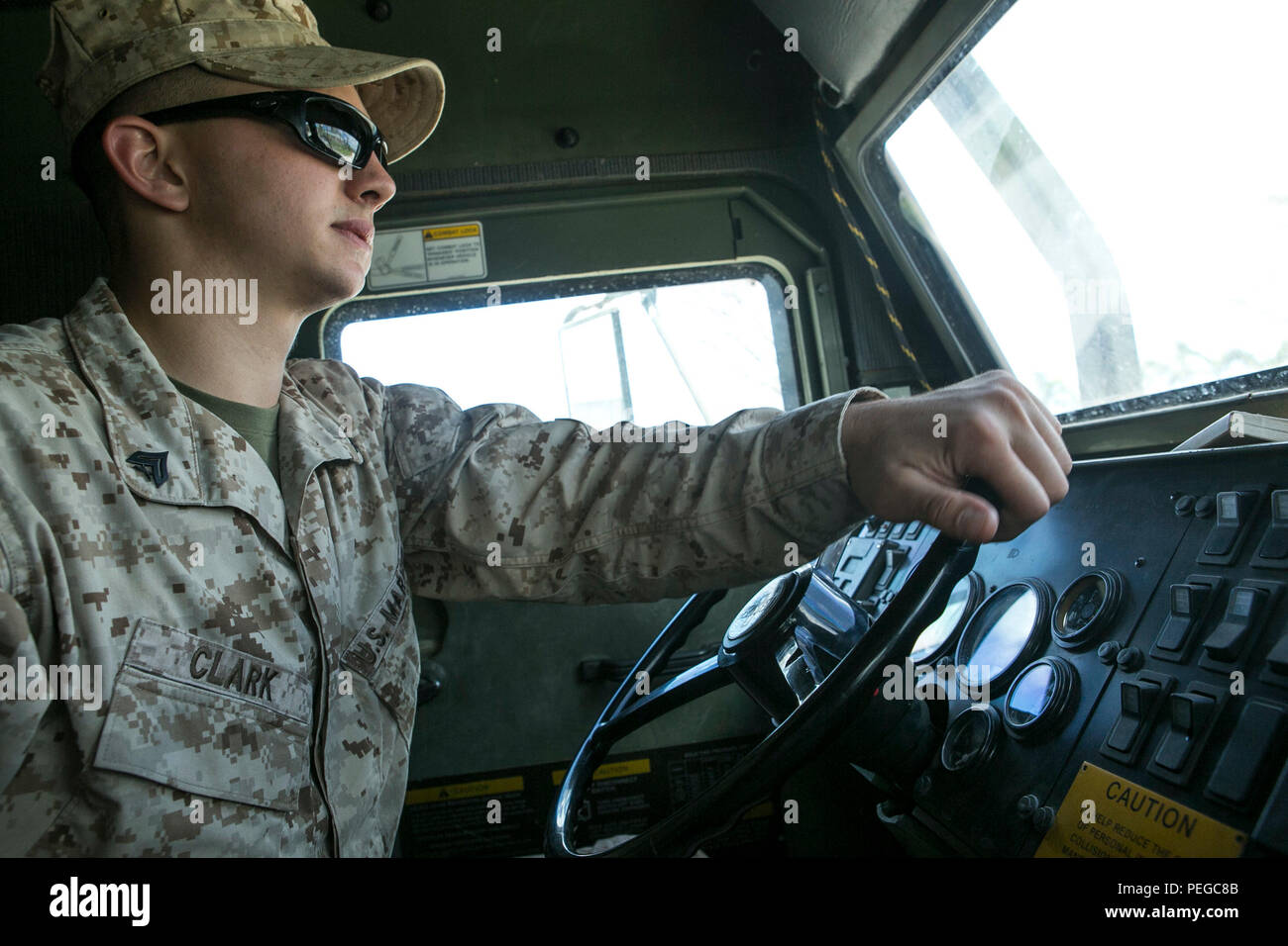 U.S. Marine Corps Cpl. Tommy Clark, with Combat Logistics Battalion 31, 31st Marine Expeditionary Unit, drives a 7-ton truck loaded with water from the USS Ashland (LSD 48) to a distribution site as part of typhoon relief efforts in Saipan, Aug. 11, 2015. The 31st MEU and the ships of the Bonhomme Richard Amphibious Ready Group are assisting the Federal Emergency Management Agency with distributing emergency relief supplies to Saipan after the island was struck by Typhoon Soudelor, Aug. 2-3. (U.S. Marine Corps photo by Lance Cpl. Brian Bekkala/Released.) Stock Photo