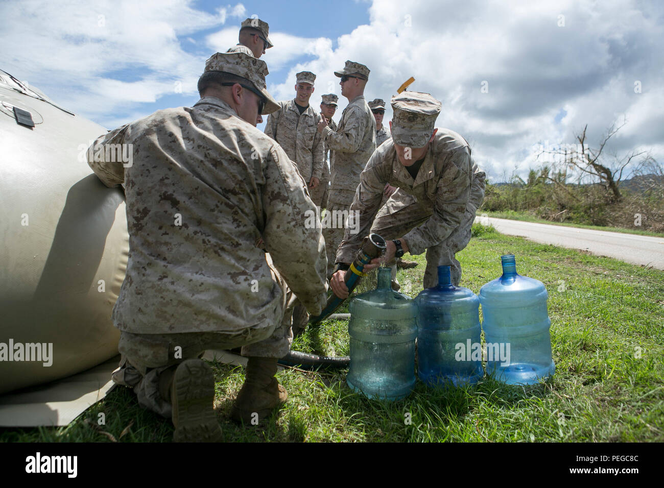 U.S. Marines with Combat Logistics Battalion 31, 31st Marine Expeditionary Unit, distribute water to local civilians as part of typhoon relief efforts in Saipan, Aug. 11, 2015. The 31st MEU and the ships of the Bonhomme Richard Amphibious Ready Group are assisting the Federal Emergency Management Agency with distributing emergency relief supplies to Saipan after the island was struck by Typhoon Soudelor, Aug. 2-3. (U.S. Marine Corps photo by Lance Cpl. Brian Bekkala/Released.) Stock Photo