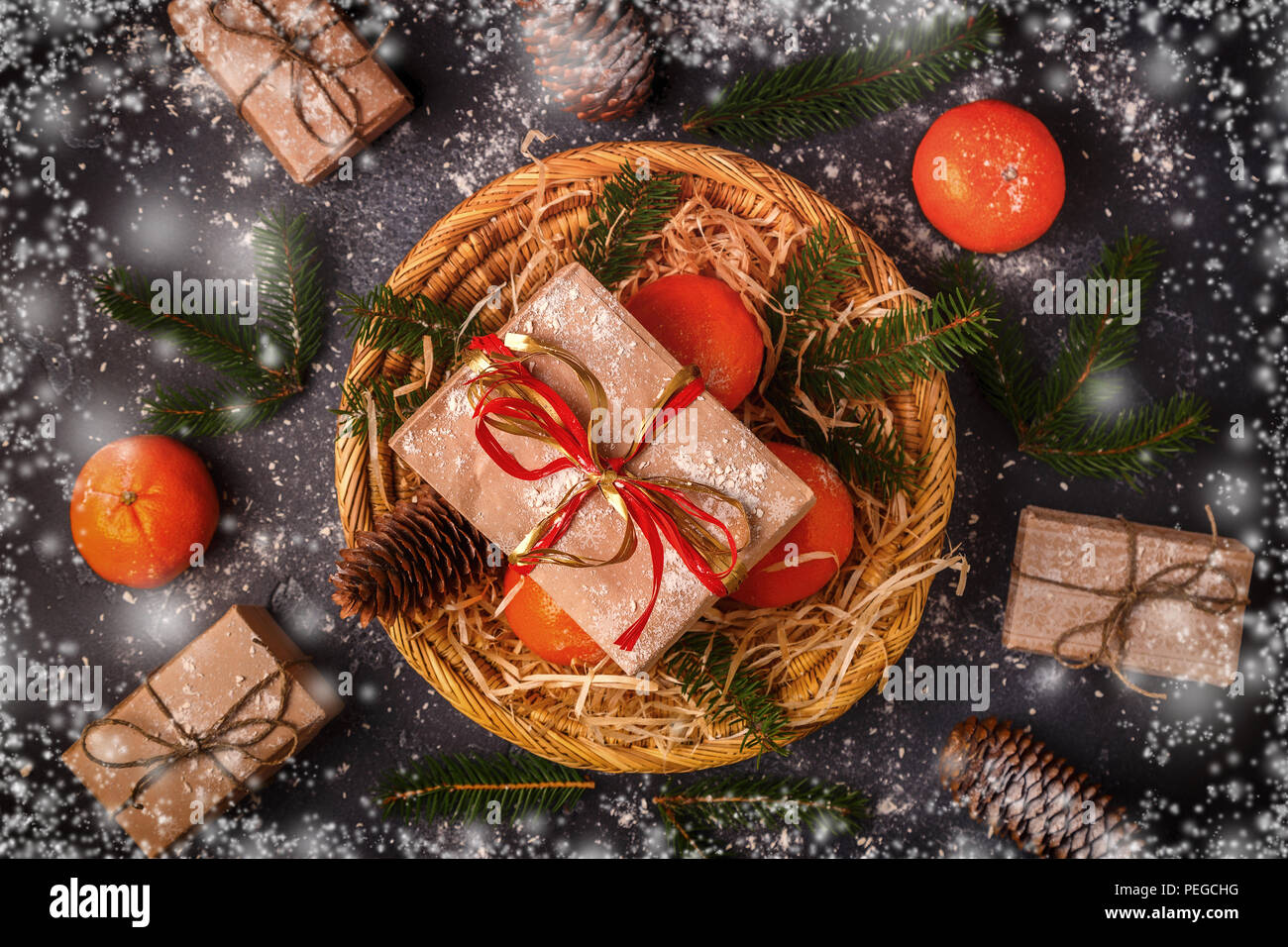 Christmas composition with tangerines, gift boxes, cones on dark  background. Stock Photo