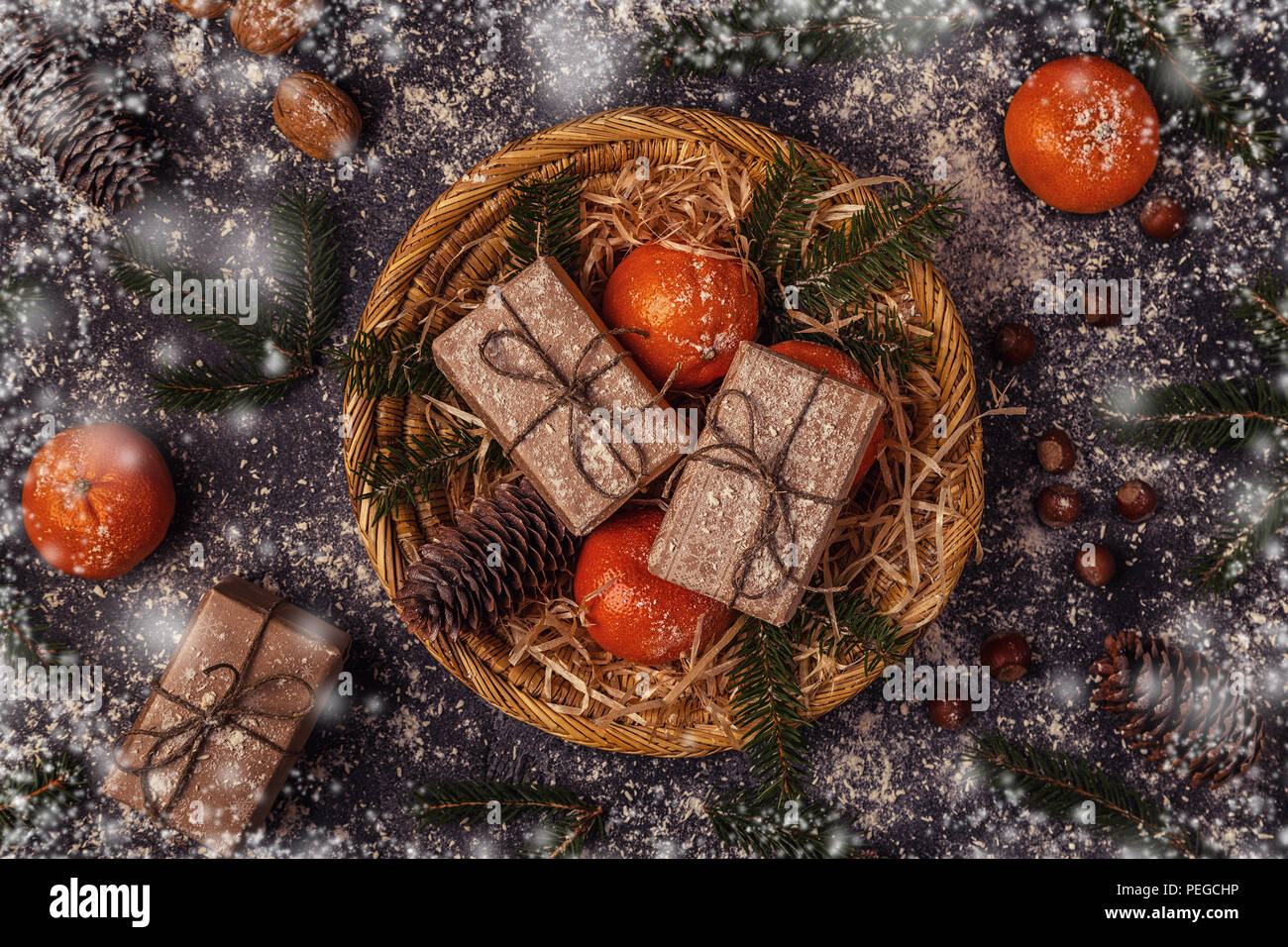 Christmas composition with tangerines, gift boxes, cones on dark  background. Stock Photo