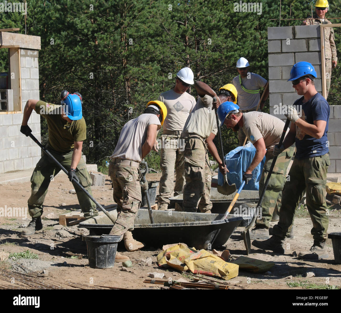 Soldiers assigned to 500th Engineer Company, 15th Engineer Battalion, 18th Military Police, work with their allies from the Norwegian Army High Readiness Force to mix concrete for a wall construction project in the Central Training Area, Estonia, Aug. 18, as part of Operation Atlantic Resolve. The U.S.-European strategic partnership is built on a foundation of shared values, experiences and commitment to a safe and stable Europe. (U.S. Army photo by Spc. Jacqueline Dowland, 13th Public Affairs Detachment) Stock Photo