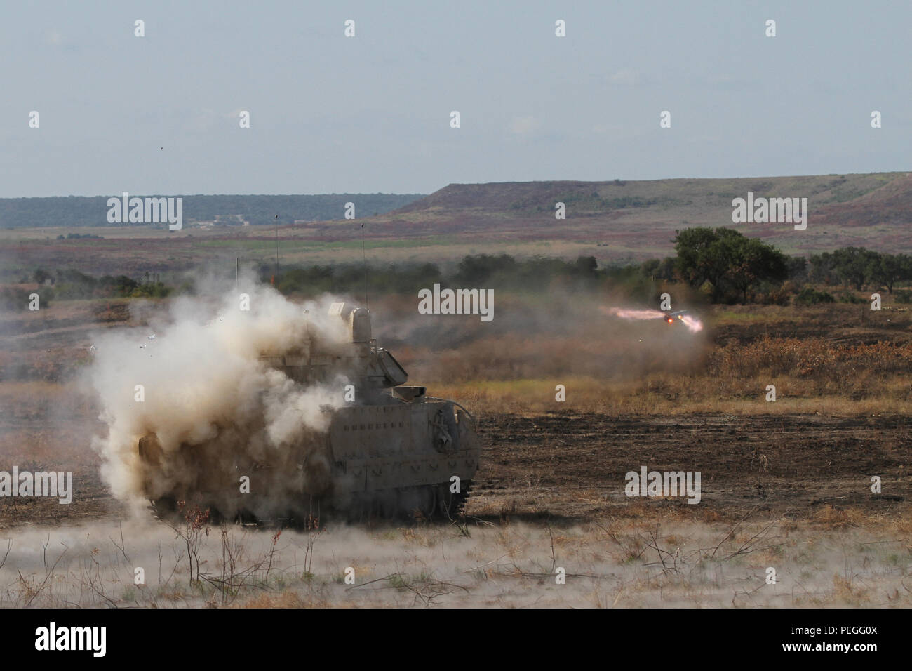 Crewmen in an M2A3 Bradley Infantry Fighting Vehicle fire a tube ...