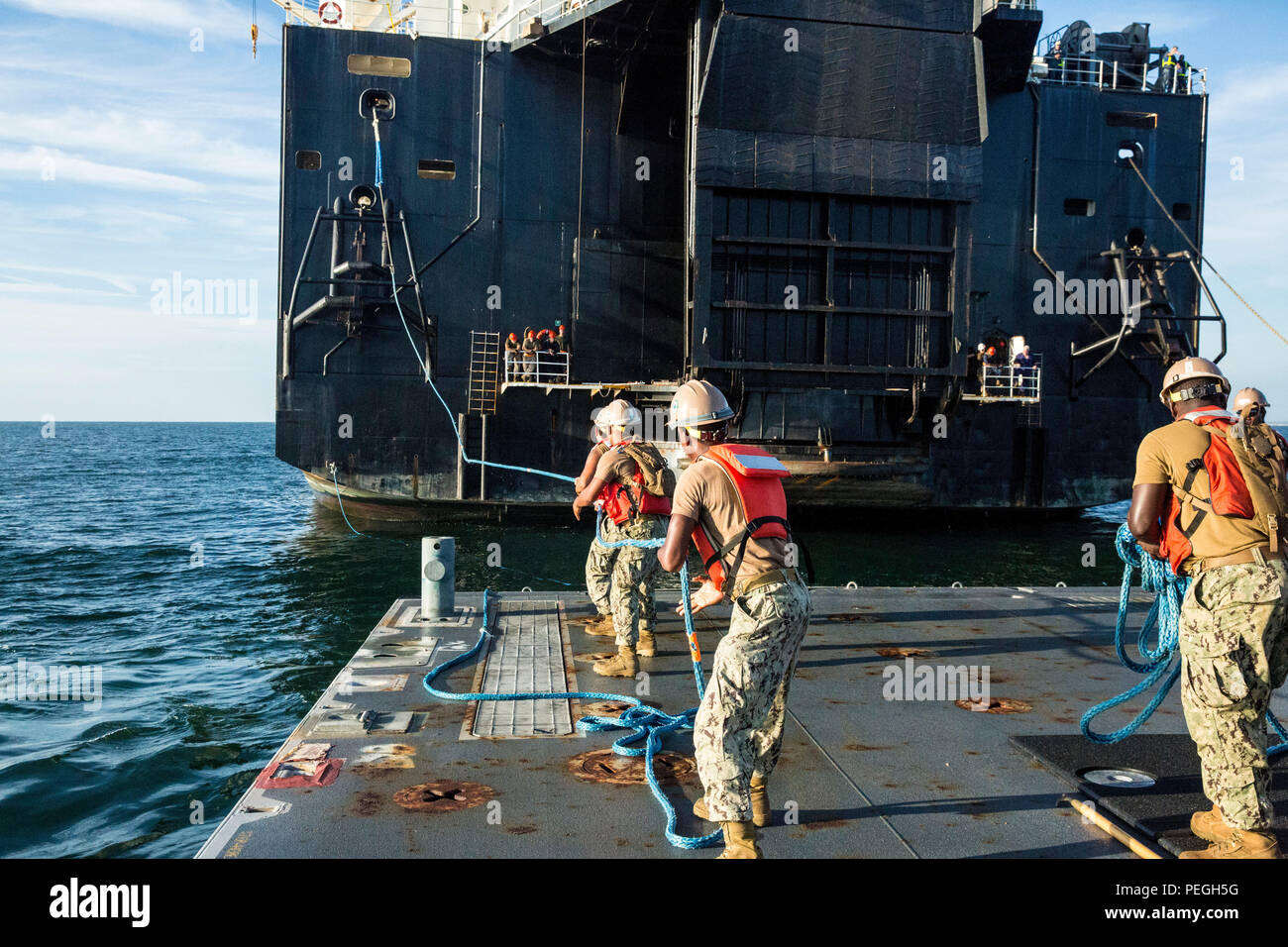 Sailors with Naval Beach Group 2 pull a rope in from the USNS 1st Lt ...