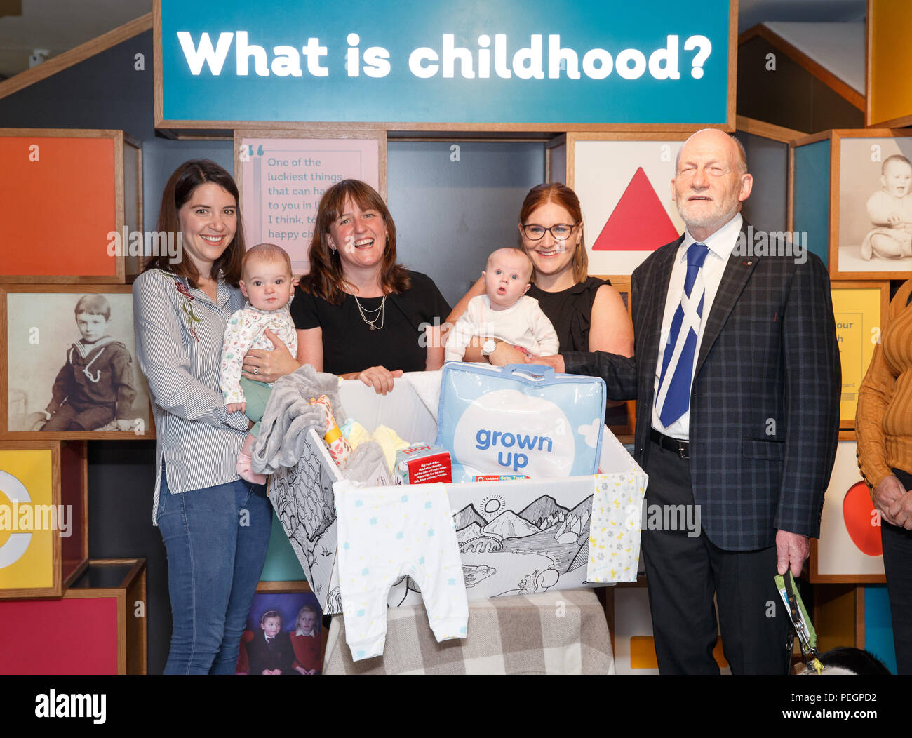 Maree Todd (third left), Minister for Children and Young People, with (left to right) Sarah Morrison and daughter Chrissie, Gillian Steele with daughter Erin and Councillor Derek Howie, marks the first anniversary of the Baby Box initiative at the Museum of Childhood, as one of the boxes is to be preserved in history as an exhibit at the Edinburgh attraction. Stock Photo