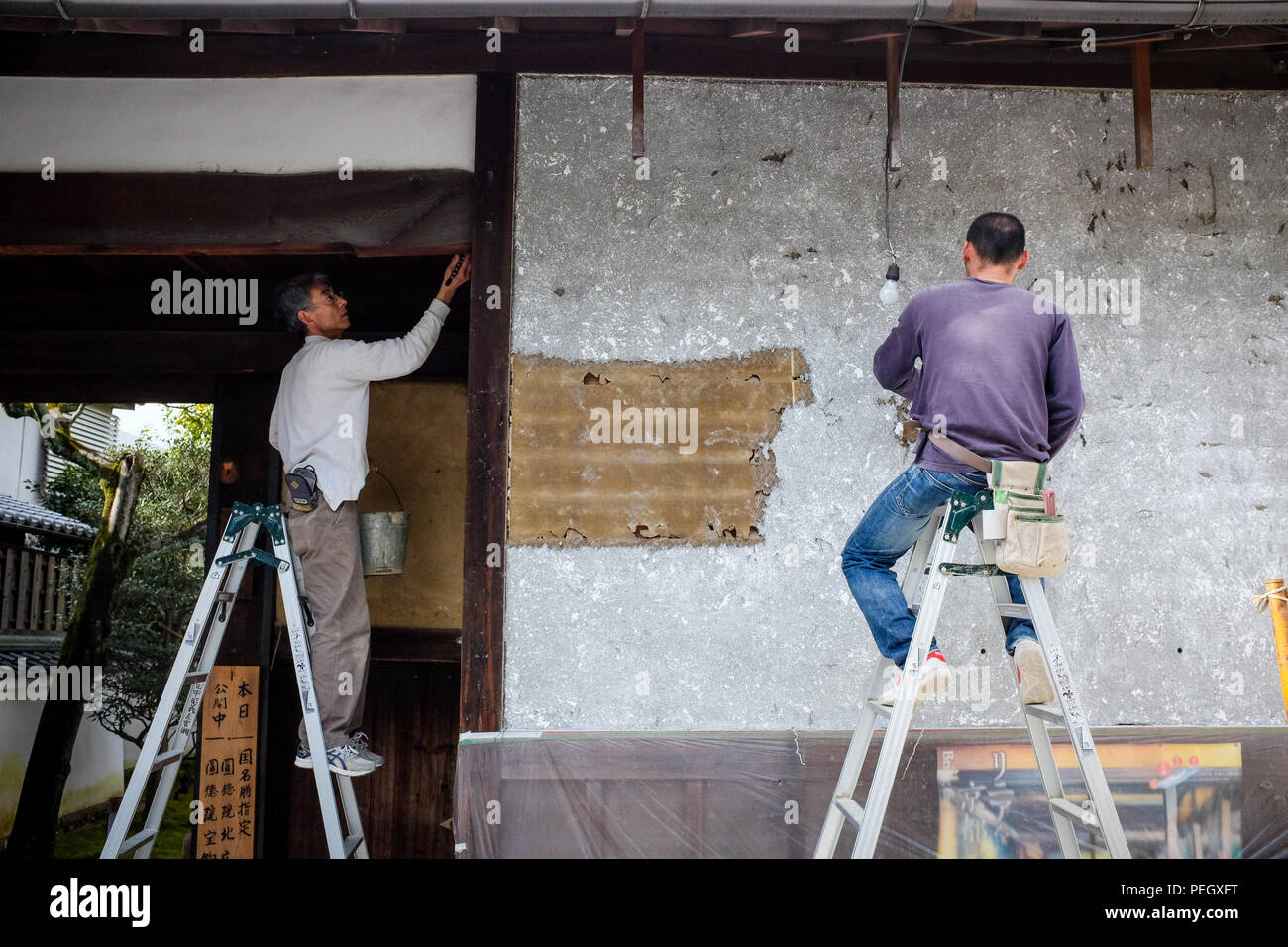Two Japanese men restoring an old building in Kyoto, Japan. Stock Photo