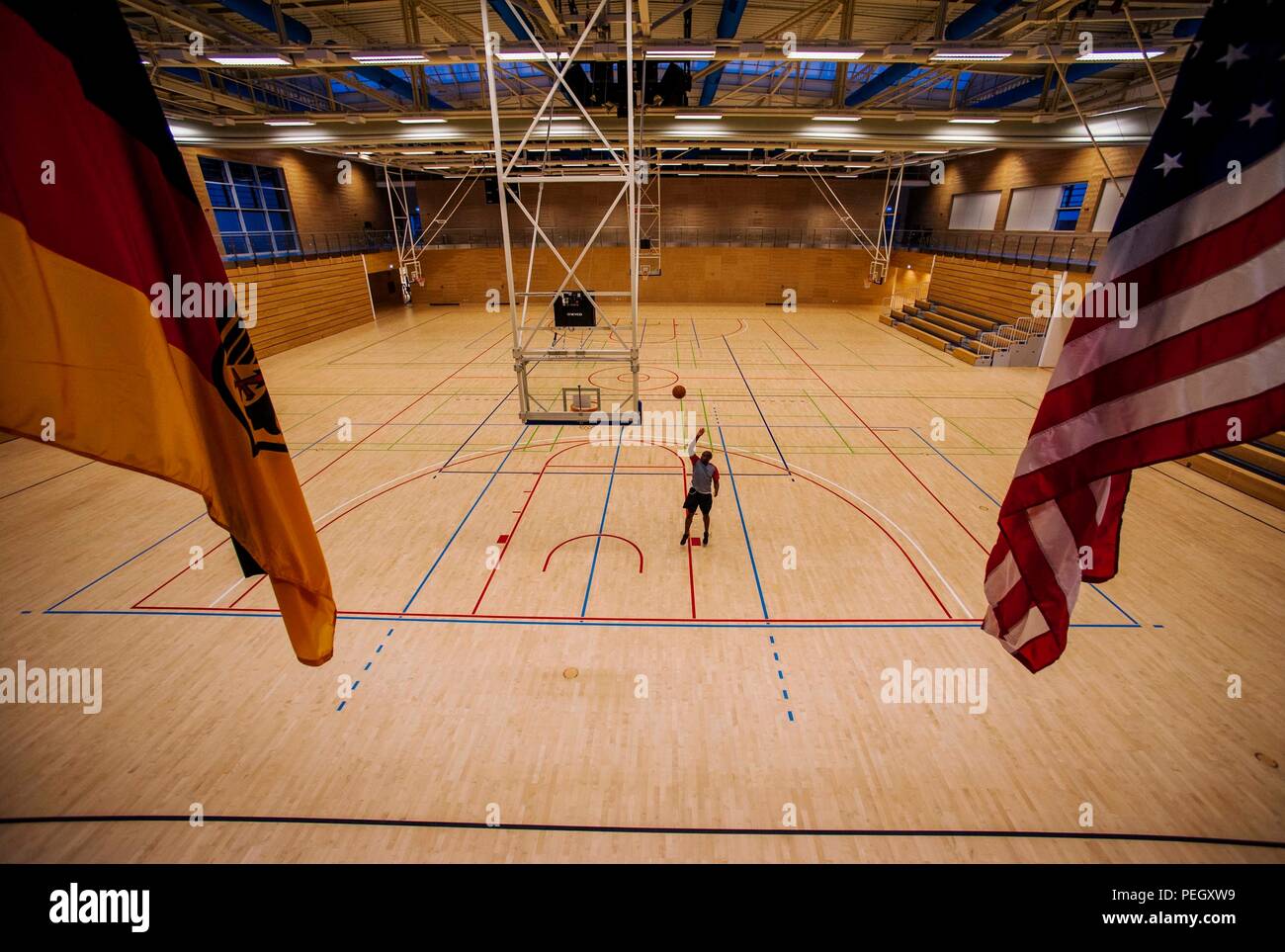 A base community member practices basketball during a swing shift at the  Eifel Powerhaus center on Spangdahlem Air Base, Germany, Aug. 20, 2015. The  fitness center offers weight-lifting machines, an indoor track,