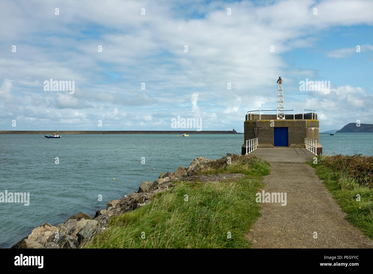 Light beacon at the end of a harbour breakwater. Stock Photo