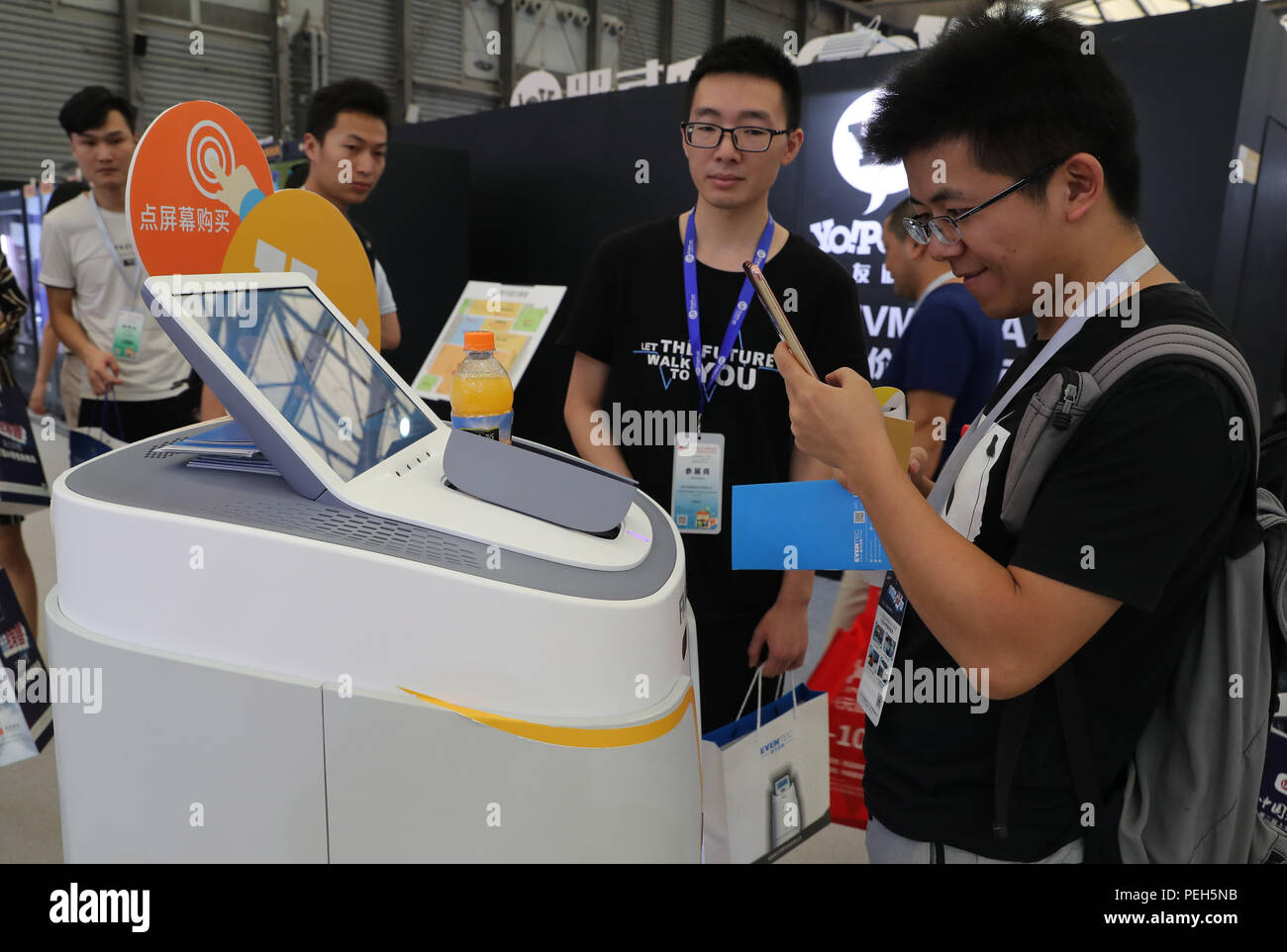 (180815) -- SHANGHAI, Aug. 15, 2018 (Xinhua) -- A visitor takes photos of an intelligent retail robot during the 2018 Shanghai International Unattended Retail Exhibition in east China's Shanghai, Aug. 15, 2018. The exhibition kicked off here on Wednesday, displaying unattended retail modes including vending machine, convenience store, restaurant, fuelling station, laundry and some other amusement and leisure services.  (Xinhua/Fang Zhe)(mcg) Stock Photo