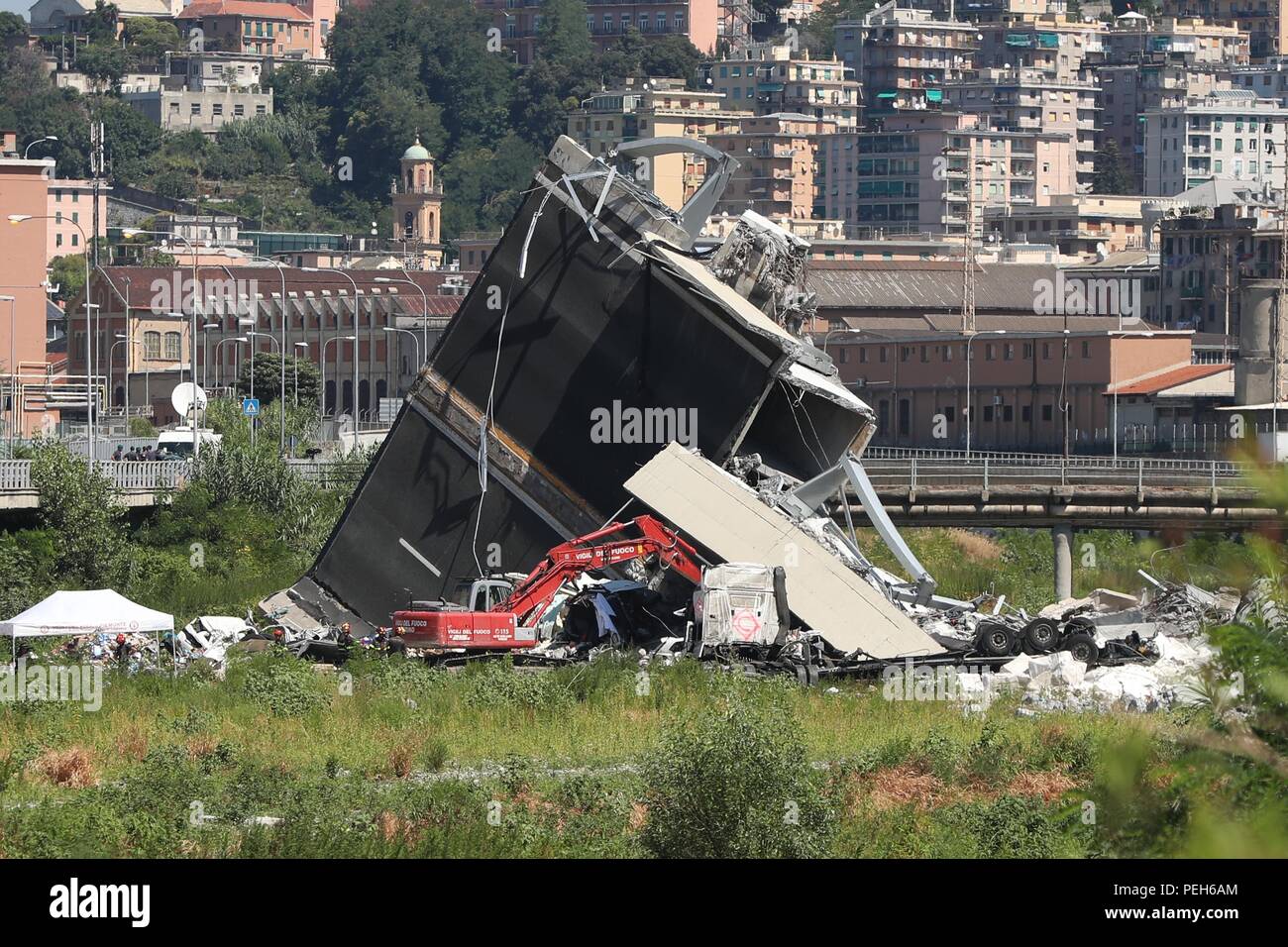 Genoa, Italy. 15th Aug, 2018. Heavy machines work at the site of the collapsed bridge in Genoa, Italy, Aug. 15, 2018. The region of Liguria surrounding the Italian northwest city of Genoa has officially filed a state of emergency request, after the dramatic collapse of a major bridge on Tuesday that caused so far 39 victims, the regional governor said on Wednesday. Credit: Zheng Huansong/Xinhua/Alamy Live News Stock Photo