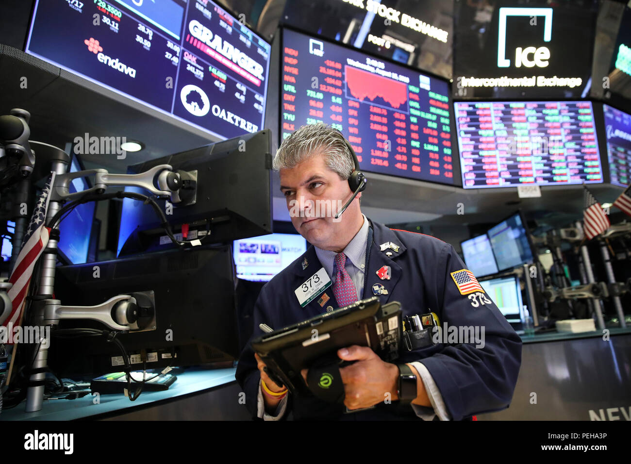 New York, USA. 15th Aug, 2018. A trader works at the New York Stock Exchange in New York, the United States, on Aug. 15, 2018. U.S. stocks closed lower on Wednesday. The Dow Jones Industrial Average fell 137.51 points, or 0.54 percent, to 25,162.41. The S&P 500 was down 21.59 points, or 0.76 percent, to 2,818.37. The Nasdaq Composite Index dropped 96.78 points, or 1.23 percent, to 7,774.12. Credit: Wang Ying/Xinhua/Alamy Live News Stock Photo