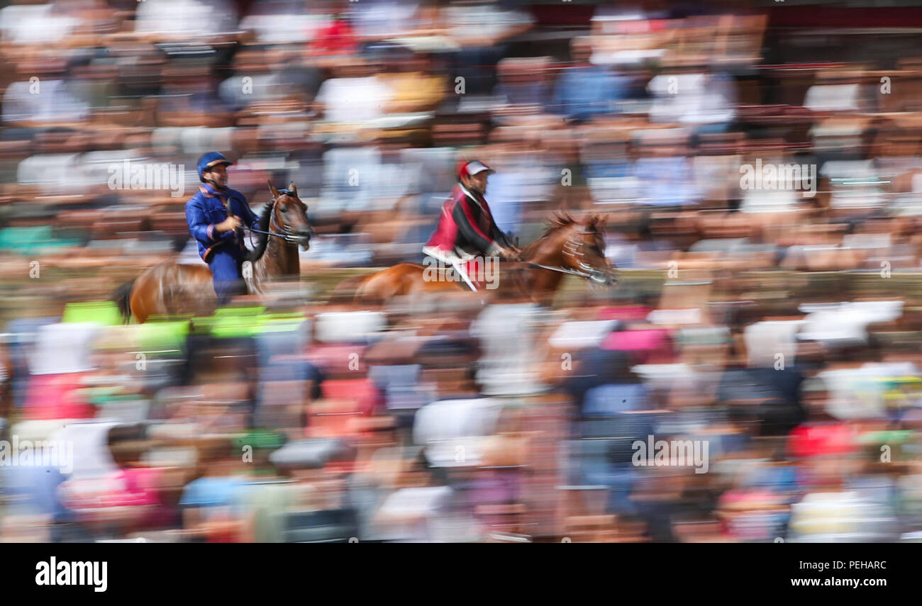 Siena, Italy. 15th Aug, 2018. Jockeys ride their horses during the third day trial of the horse race in Siena, Italy, August 15, 2018. A traditional horse race, known as 'Palio di Siena' in Italian, is held in Italian historical city Siena, attracting tens of thousands of spectators. The horse race in Siena dates back to medieval period and is held on July 2 and August 16 every year. Three-day trials are held before the final race. Credit: Jin Yu/Xinhua/Alamy Live News Stock Photo