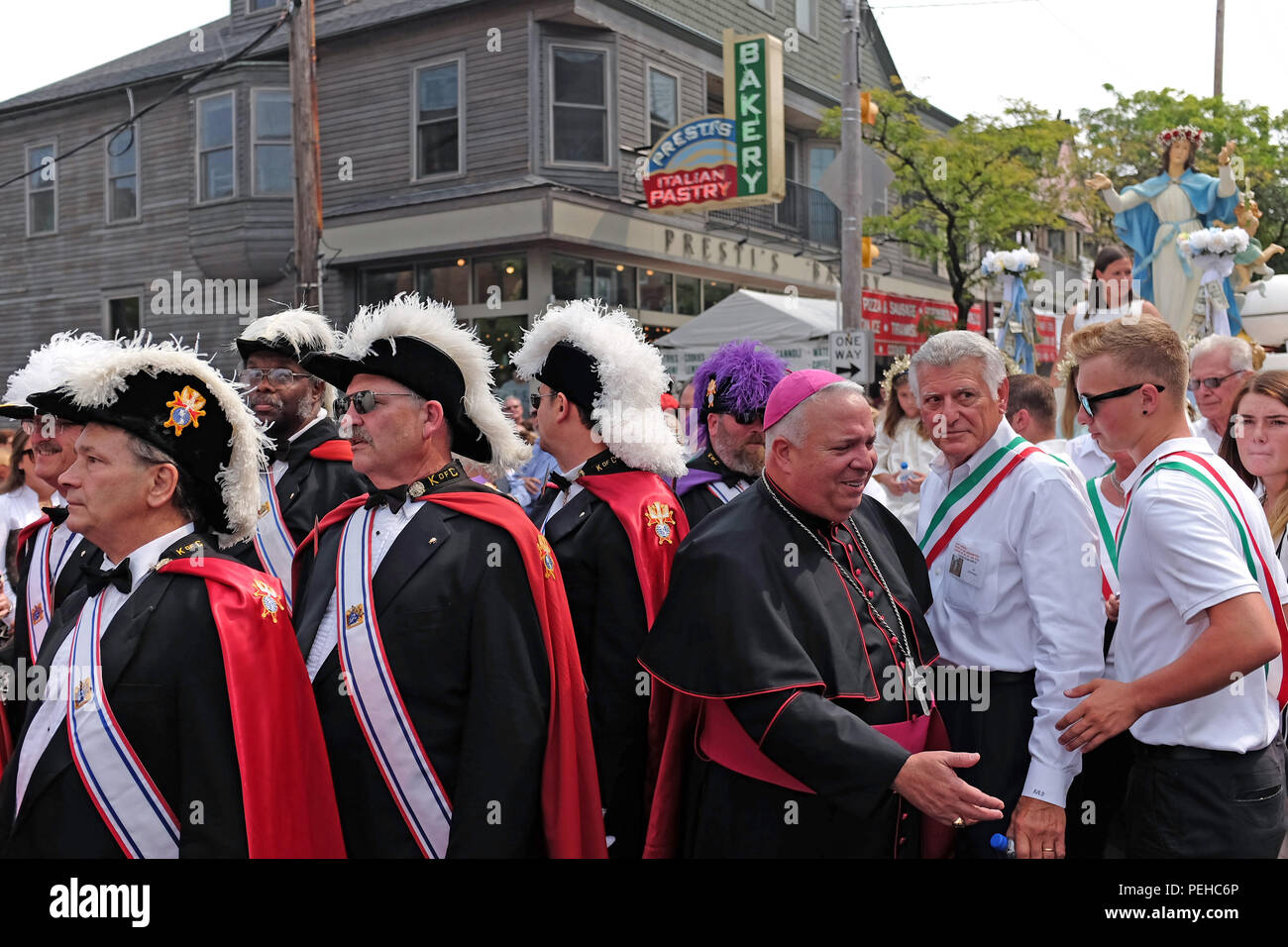 Cleveland, Ohio, USA. 15th Aug, 2018. Participants in the 120th Feast of the Assumption procession in Cleveland's Little Italy prepare for commencement.  The Holy Rosary church Virgin Mary is ready to be paraded through the streets of this Italian enclave while procession participants including the Cleveland Bishop and members of the K of C wait in front of Presti's Bakery on Mayfield Road.  Credit: Mark Kanning/Alamy Live News. Stock Photo