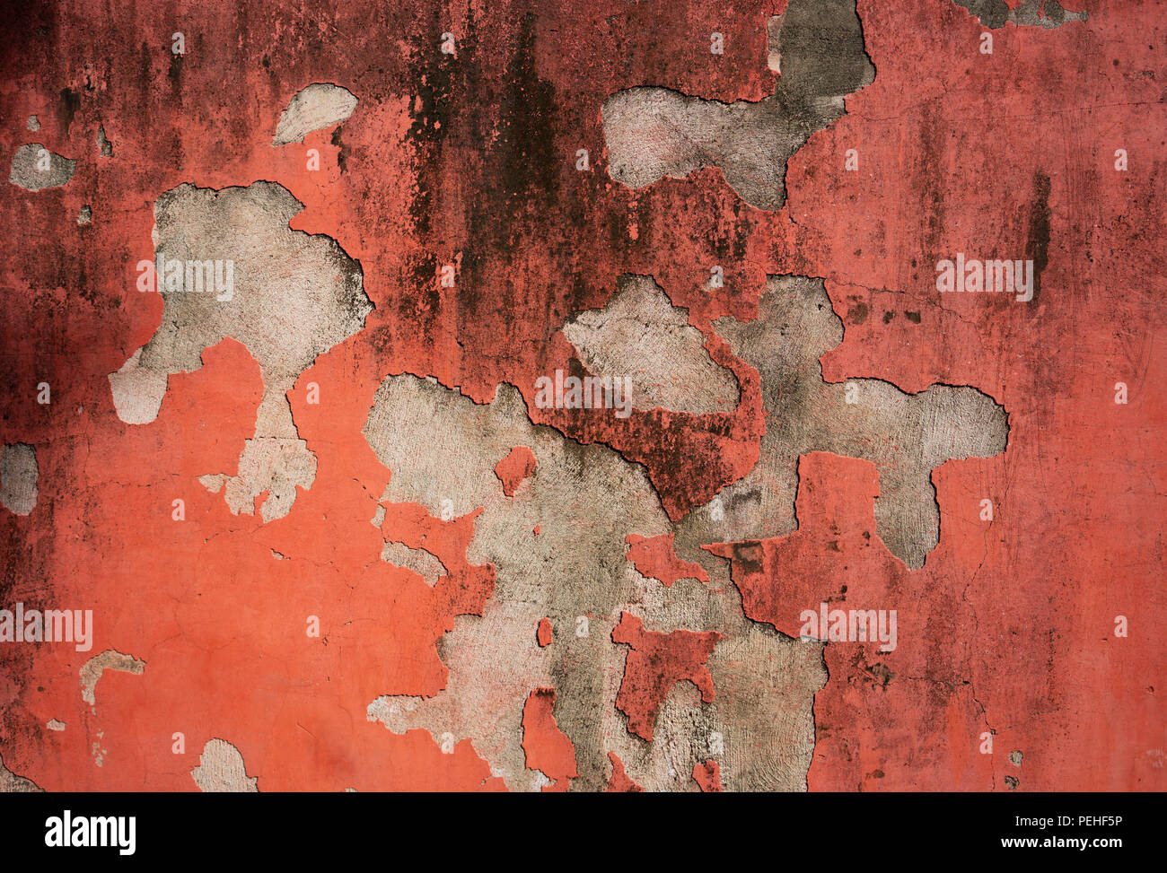 Old Red crumbled painted cement wall for background Stock Photo
