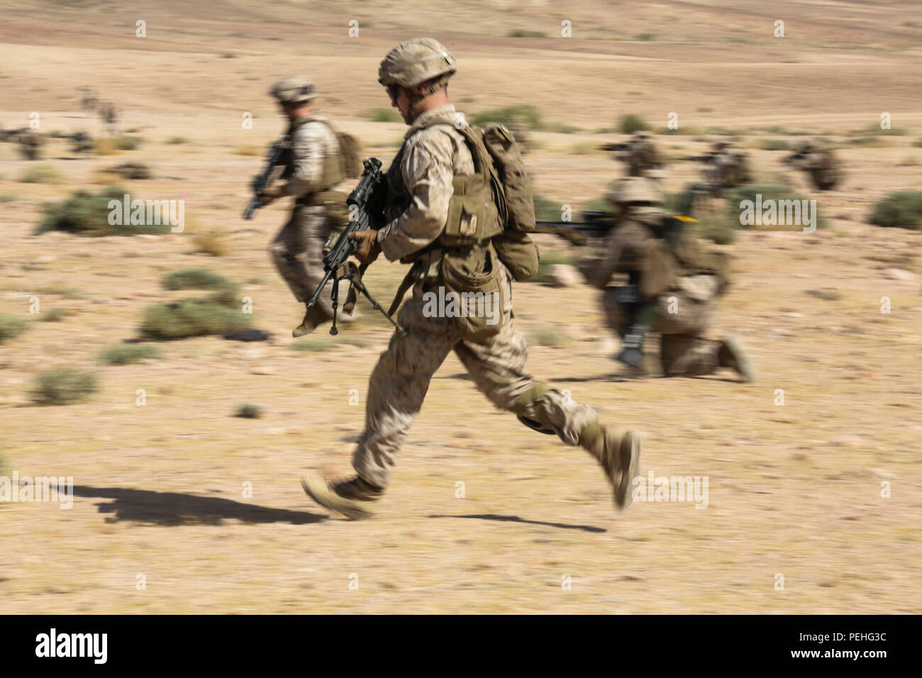 Southwest Asia (Aug. 18, 2015) U.S. Marine Lance Cpl. Robert Hole rushes with his fellow Marines while simulating a squad attack during sustainment training. Hole is a team leader with India Company, Battalion Landing Team 3rd Battalion, 1st Marine Regiment, 15th Marine Expeditionary Unit.  The 15th MEU, embarked aboard the ships of the Essex Amphibious Ready Group, is a forward-deployed, flexible sea-based Marine air-ground task force capable of engaging with regional partners and contributing to regional security. (U.S. Marine Corps photo by Sgt. Jamean Berry/Released) Stock Photo