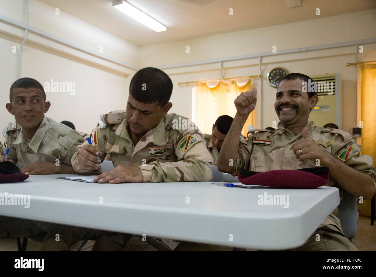 An Iraqi soldier attending the noncommissioned officer academy gives thumbs up after completing a map reading test at Camp Taji, Iraq, Aug. 23, 2015. Task Group Taji spearheaded the academy concept in order to teach Iraqi NCOs how to train and care for their soldiers in different situations. Through professional development with the Iraqi NCOs, Combined Joint Task Force – Operation Inherent Resolve is empowering the Iraqi security forces in the fight against the Islamic State of Iraq and the Levant. (U.S. Army photo by Spc. Paris Maxey/Released) Stock Photo