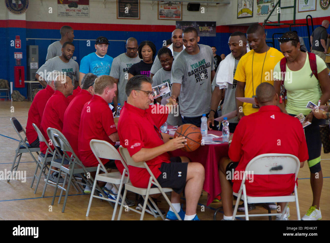 Current and former NCAA basketball coaches sign autographs and chat with basketball fans after