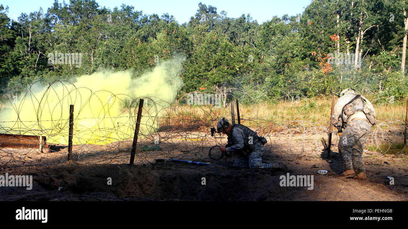 An Ohio National Guard Soldier from the St. Marys, Ohio, Company A, Special Troops Battalion, 37th Brigade emplaces C4 in order to breach an obstacle during training at Camp Grayling Joint Maneuver Training Center, Grayling, Mich., Aug. 21, 2015. The Soldiers are participating in the eXportable combat training capability program designed to certify platoon proficiency in coordination with 1st Army. (U.S. Army National Guard photo by 1st Lt. Tyler Piper/Released) Stock Photo