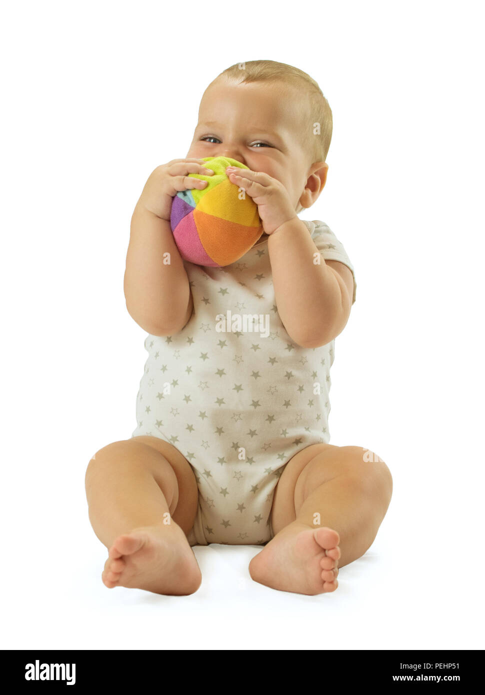 Cute baby boy holding the ball in front of his face and smiling. Isolated on white background. Stock Photo