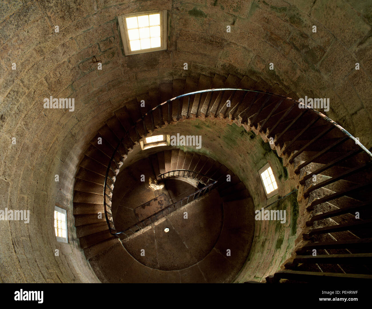 Looking S down the spiral stone steps of Old Light, Lundy Island, Devon, UK, from just below the first full floor to the half floor & ground level. Stock Photo