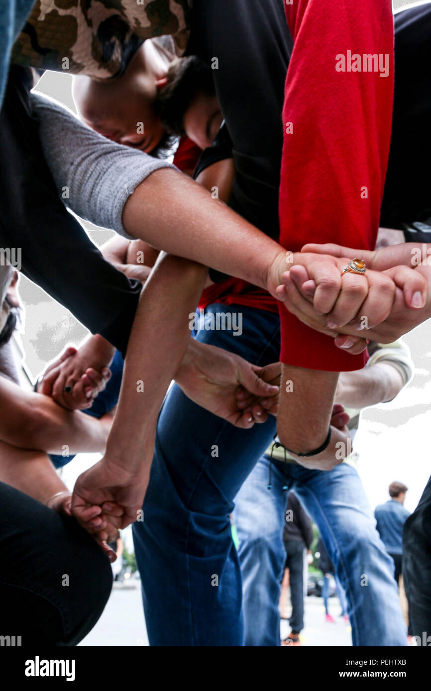 Locals and visitors attending the sixth annual Anibar International Animation Festival try to untangle their arms during a 'human knot' game Aug. 22, 2015, in Peja, Kosovo. The game was led by U.S. Army Soldiers—deployed to serve on NATO’s peace support mission in Kosovo—who volunteered their time to support the Pristina Rotary Club’s Violence-Free Future Program, which aims to promote pro-social behaviors among Kosovo’s youth through open discussion. (U.S. Army photo by Staff Sgt. Mary Junell, Multinational Battle Group-East) Stock Photo