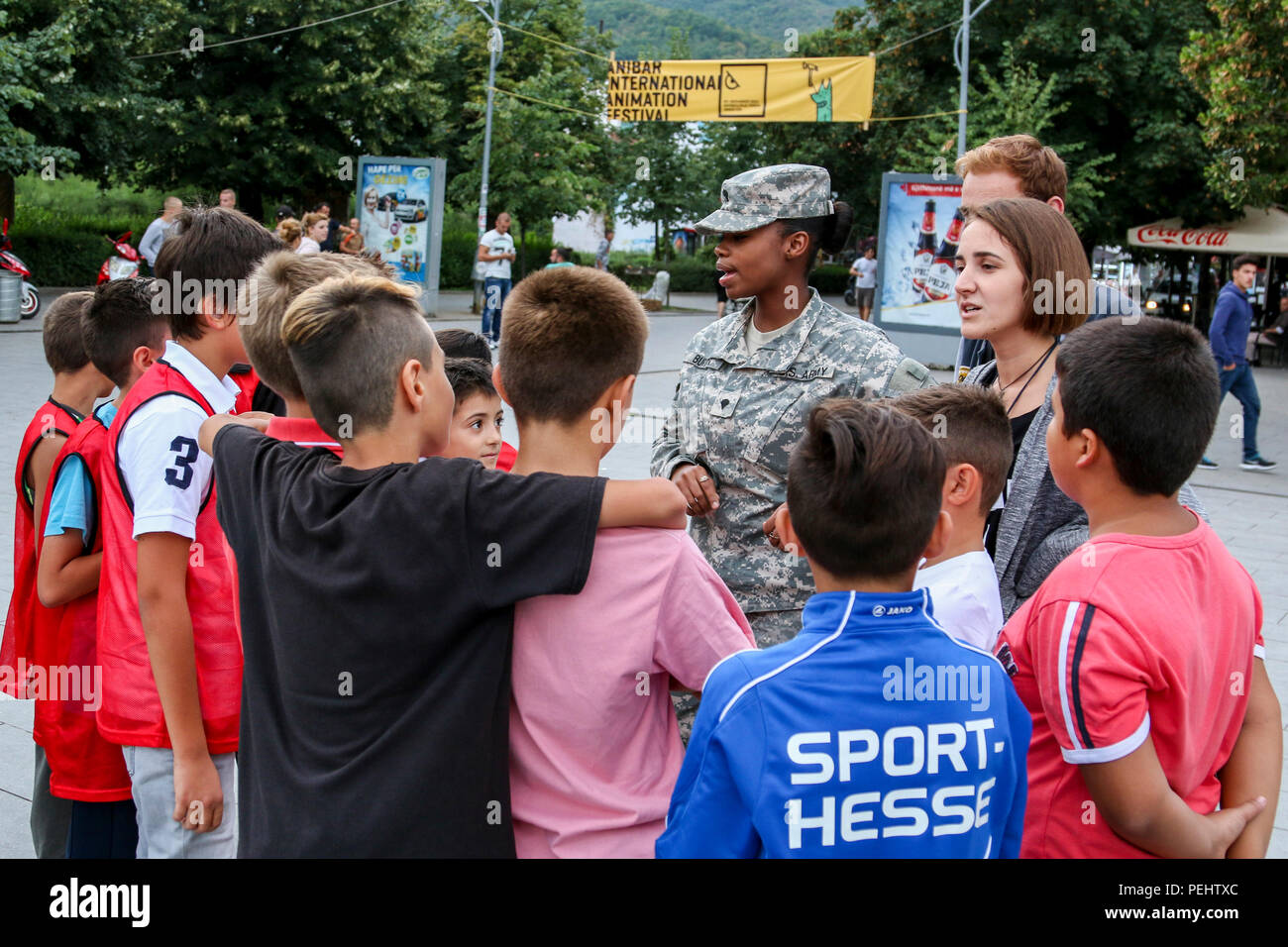 Spc. Travanda Burton, a U.S. Army Reserve Soldier deployed to Kosovo with the 345th Combat Support Hospital, talks to a group of kids about teamwork during the Anibar International Animation Festival Aug. 22, 2015, in Peja, Kosovo, as part of the Pristina Rotary Club’s Violence-Free Future program. Burton volunteered her off-time to lead kids in games and discussions to promote pro-social behaviors among Kosovo’s youth. Burton and the 345th CSH serve as Multinational Battle Group-East’s Task Force Medical, serving on the 20th iteration of NATO’s peace support mission in Kosovo (U.S. Army photo Stock Photo