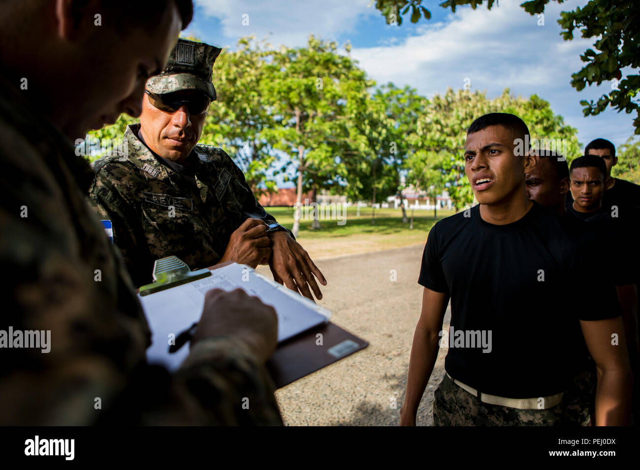 U.S. Marine Corps Cpl. Diego Rendon, left, the team leader for Security Cooperation Team-Honduras, Special Purpose Marine Air-Ground Task Force-Southern Command takes down scores for Honduran marines after the 880-meter portion of the combat fitness test at Naval Base Puerto Castilla, Honduras, Aug. 12, 2015. SCT-Honduras is currently deployed as part of the SPMAGTF-SC to assist the Centro de Adiestramiento Naval with implementing a training curriculum to create a Honduran marine Program.  (U.S. Marine Corps Photo by Cpl. Katelyn Hunter/Released). Stock Photo