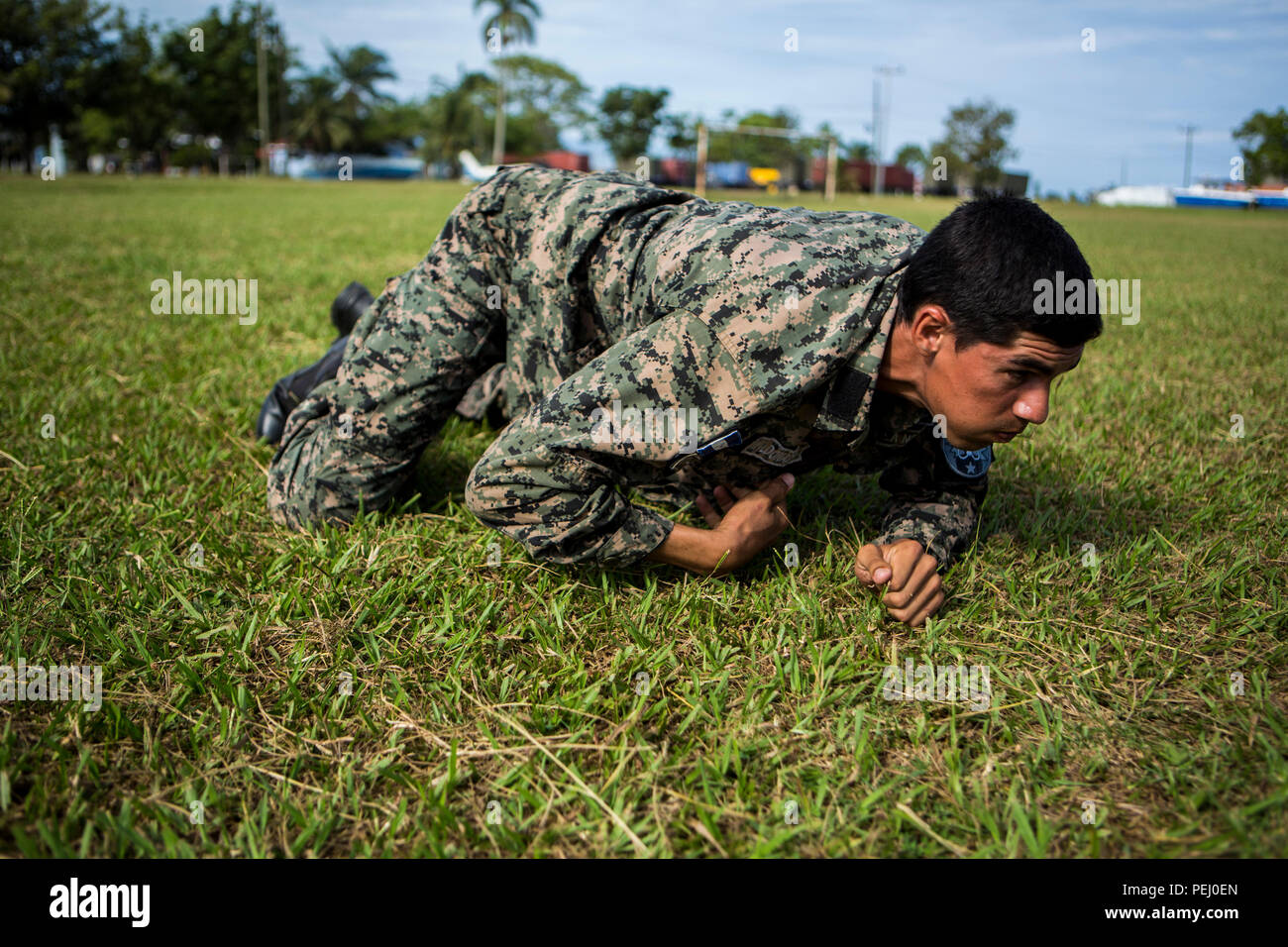 A Honduran marine performs the low crawl during the maneuver under fire portion of the combat fitness test at Naval Base Puerto Castilla, Honduras, Aug. 12, 2015. U.S. Marines with Security Cooperation Team-Honduras, Special Purpose Marine Air-Ground Task Force-Southern Command monitored the event. SCT-Honduras is currently deployed as part of the SPMAGTF-SC to assist the Centro de Adiestramiento Naval with implementing a training curriculum to create a Honduran marine Program.  (U.S. Marine Corps Photo by Cpl. Katelyn Hunter/Released). Stock Photo