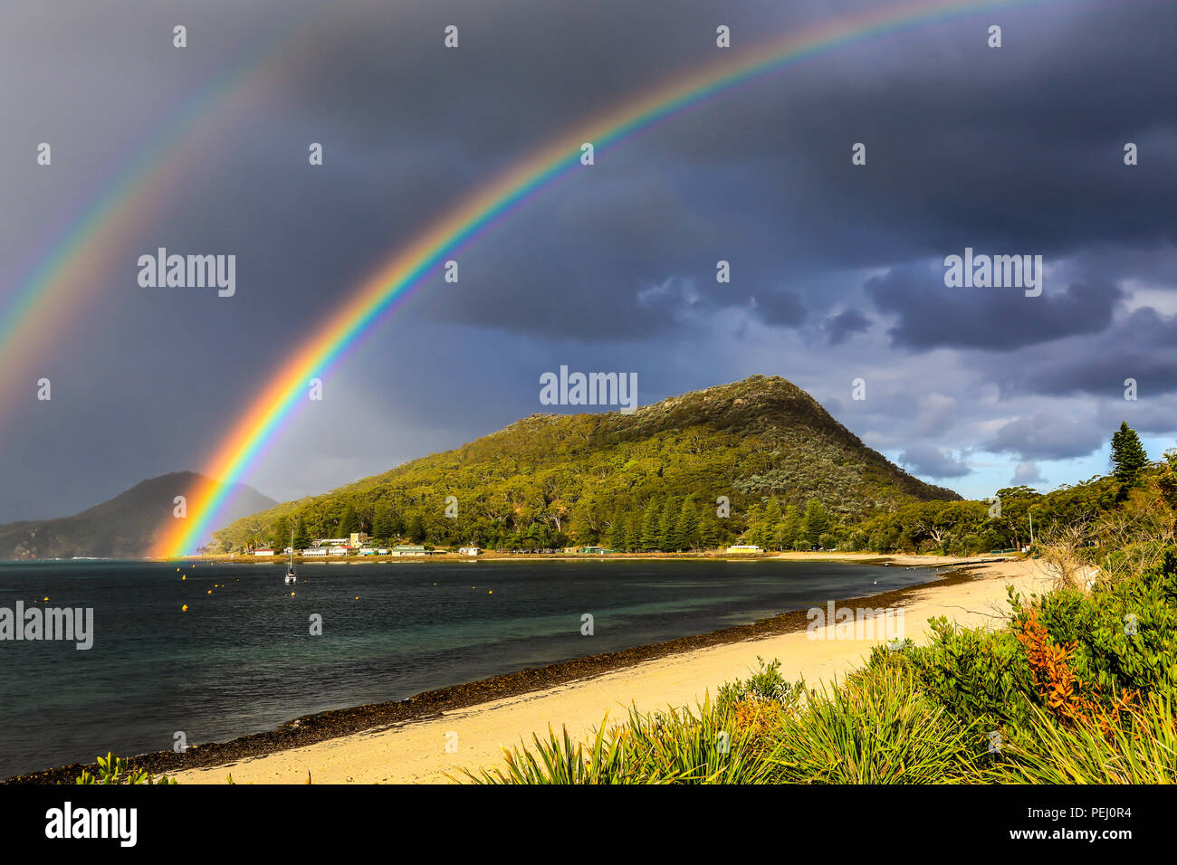 Double rainbow over mountain and beach Stock Photo - Alamy