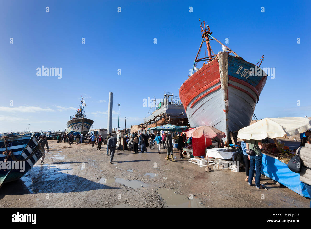 ESSAOUIRA, MOROCCO – JANUARY 8, 2018: Tourists and local people visiting the traditional the fish market at the harbor of Essaouira Stock Photo