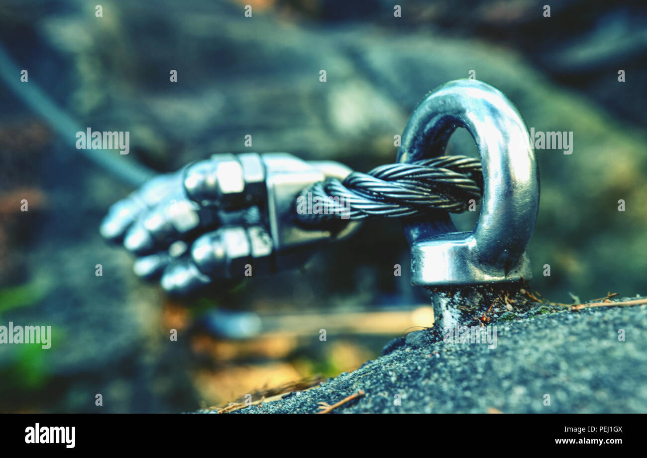 Via ferrata steel rope on a rock detail. Steel chrome anchores in rock ...