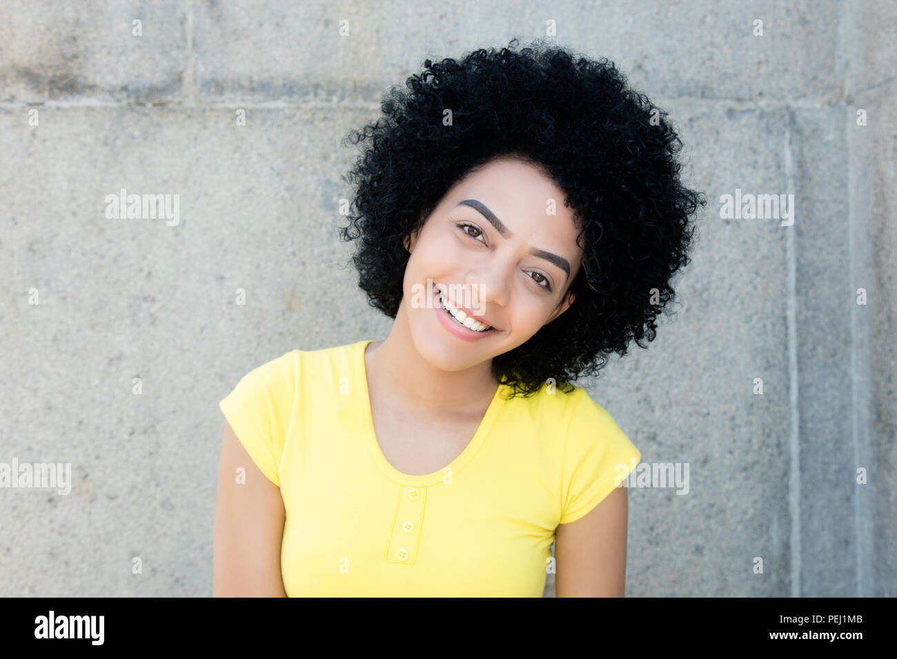 Portrait of a beautiful young adult woman with curly black hair outdoors with copy space Stock Photo