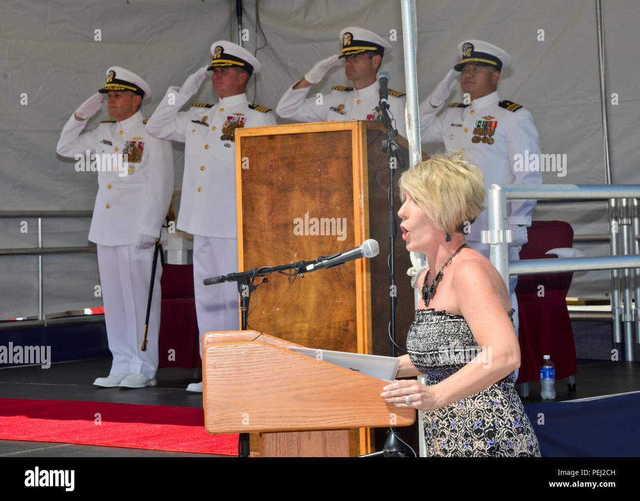 150826-N-YM720-028 POLARIS POINT, Guam (Aug. 26, 2015) Krista Callahan sings the national anthem during a change of command ceremony for the submarine tender USS Frank Cable (AS 40). During the ceremony, Capt. Mark Benjamin, middle left, was relieved by Capt. Andrew St. John, middle right, as commanding officer of Frank Cable.  Frank Cable, forward deployed to the island of Guam, conducts maintenance and support of submarines and surface vessels deployed in the U.S. 7th Fleet area of responsibility.    (U.S. Navy photo by Mass Communication Specialist 3rd Class Allen Michael McNair) Stock Photo
