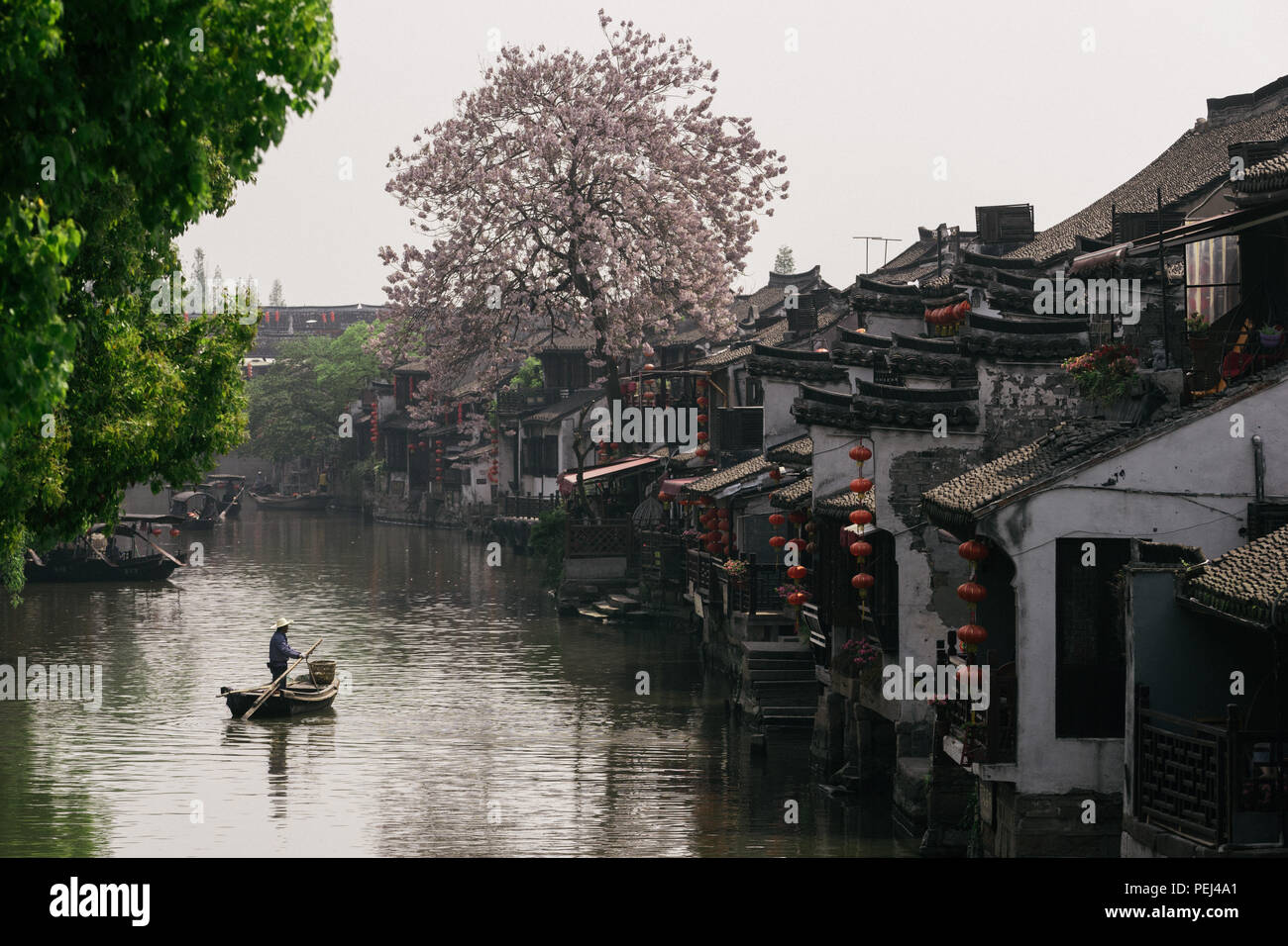 Man standing on a boat in Xitang, China Stock Photo