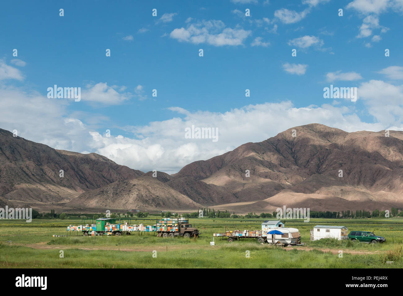 Rural agricultural scene with mountainous landscape near Bokonbayevo, Kyrgyzstan. Stock Photo