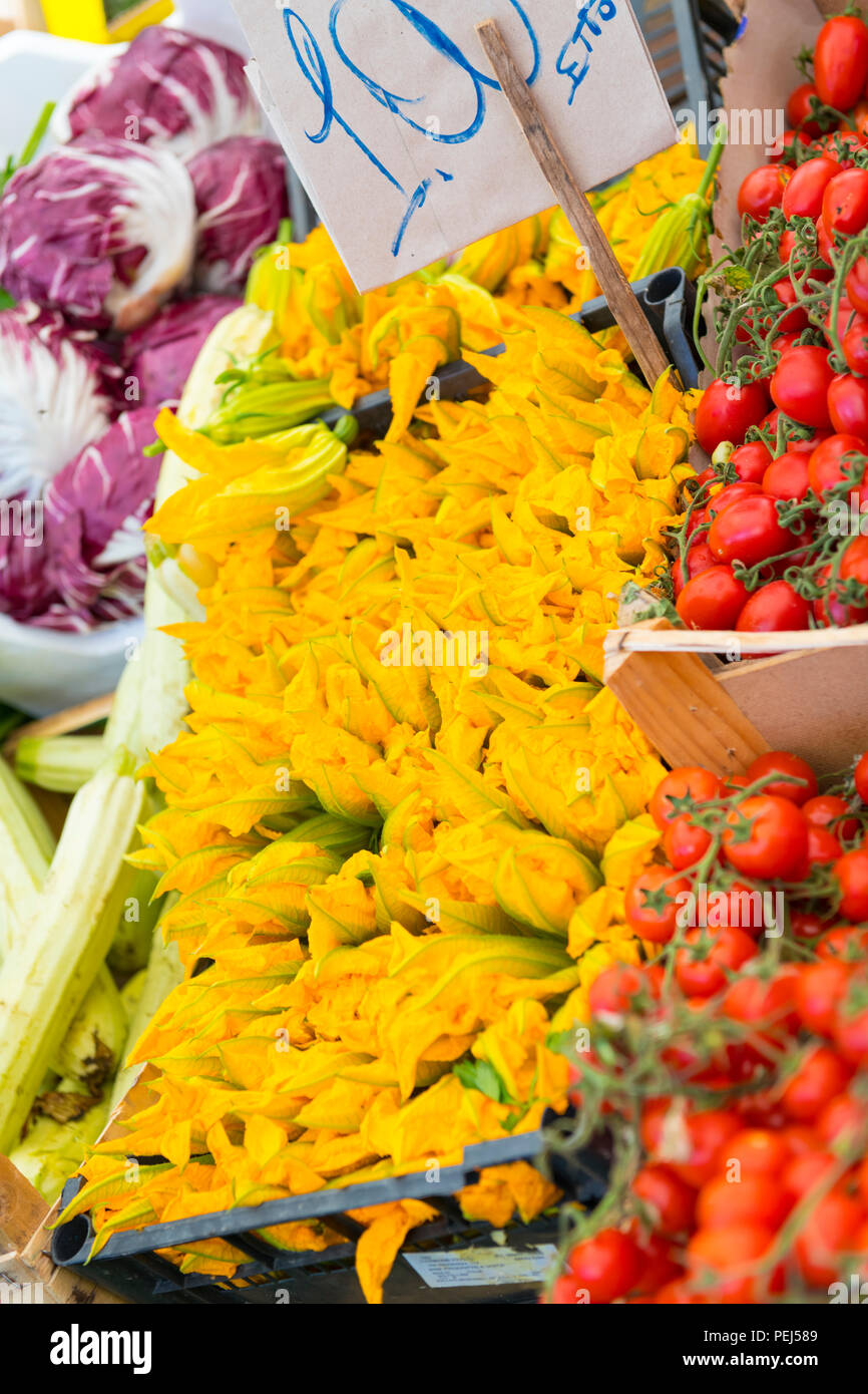 Italy Sicily Syracuse Siracusa Ortygia historic street fresh food & fish market bright yellow courgette flowers vegetable stall tomatoes radicchio Stock Photo