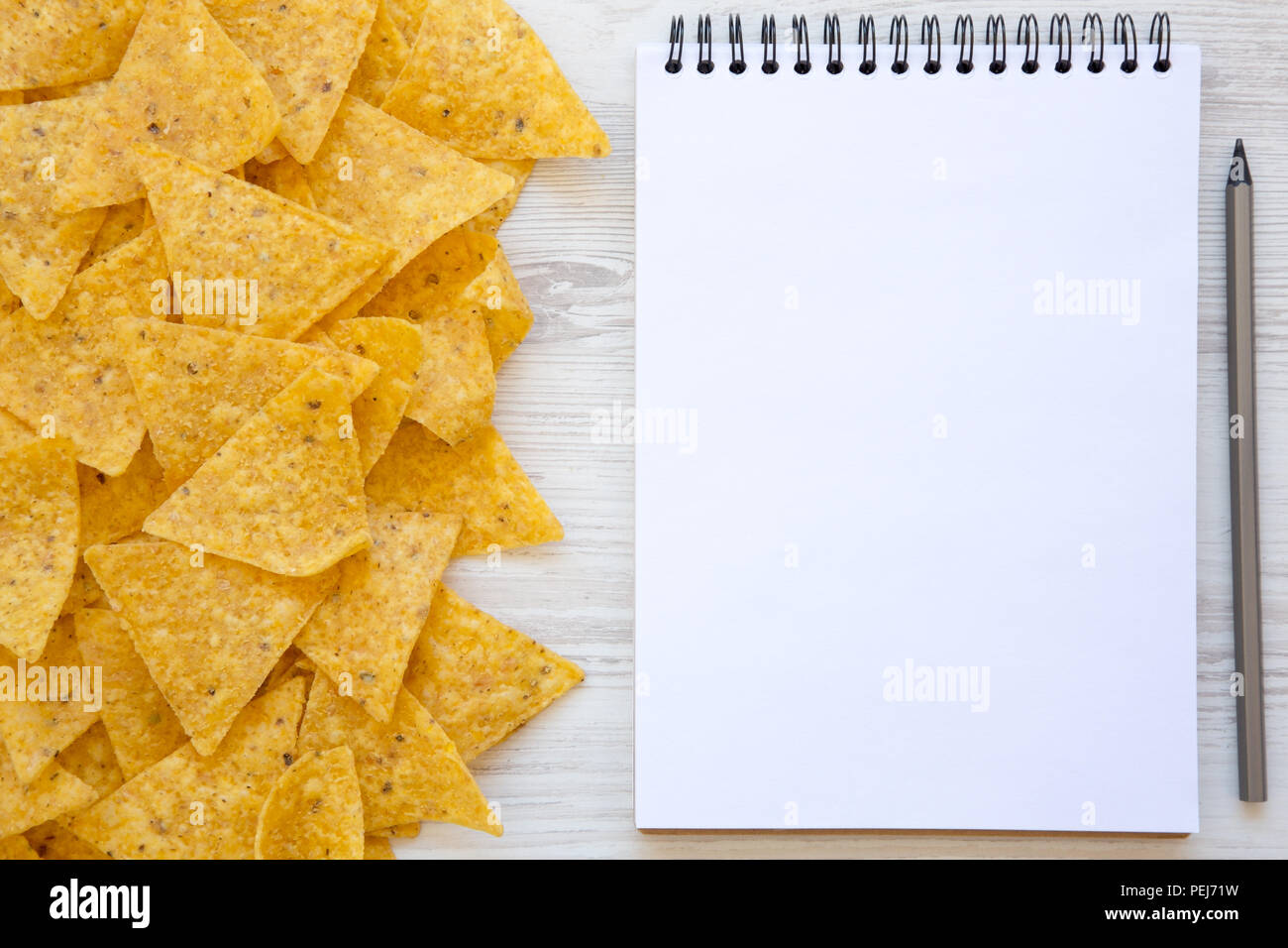 Notepad Chip Tortilla chips with blank notepad on white wooden table, top view ...