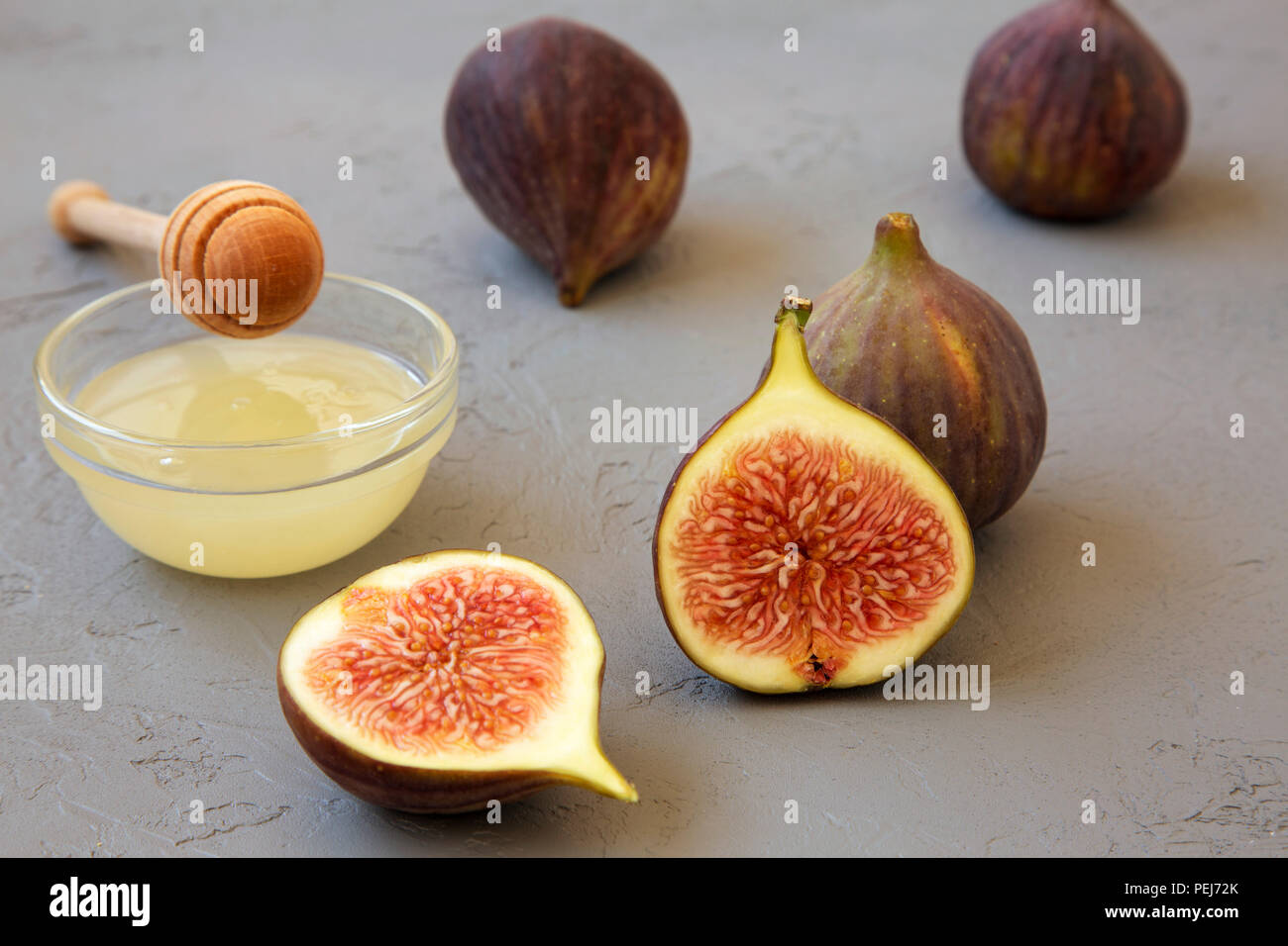 Fresh figs with honey on gray background, side view. Closeup. Stock Photo