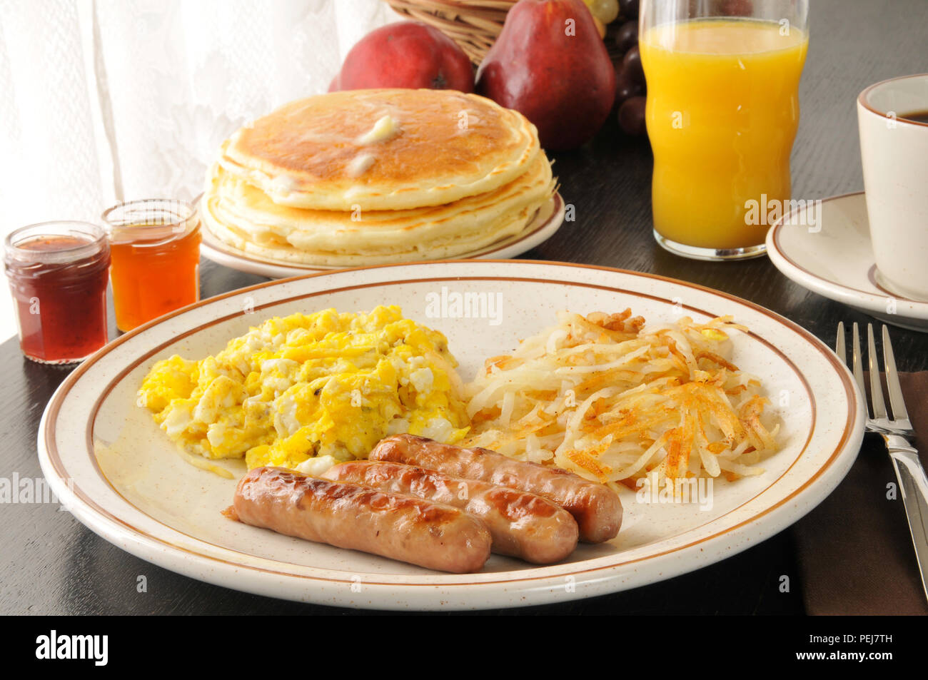 Sausage and scrambled eggs with hash browns and pancakes Stock Photo ...