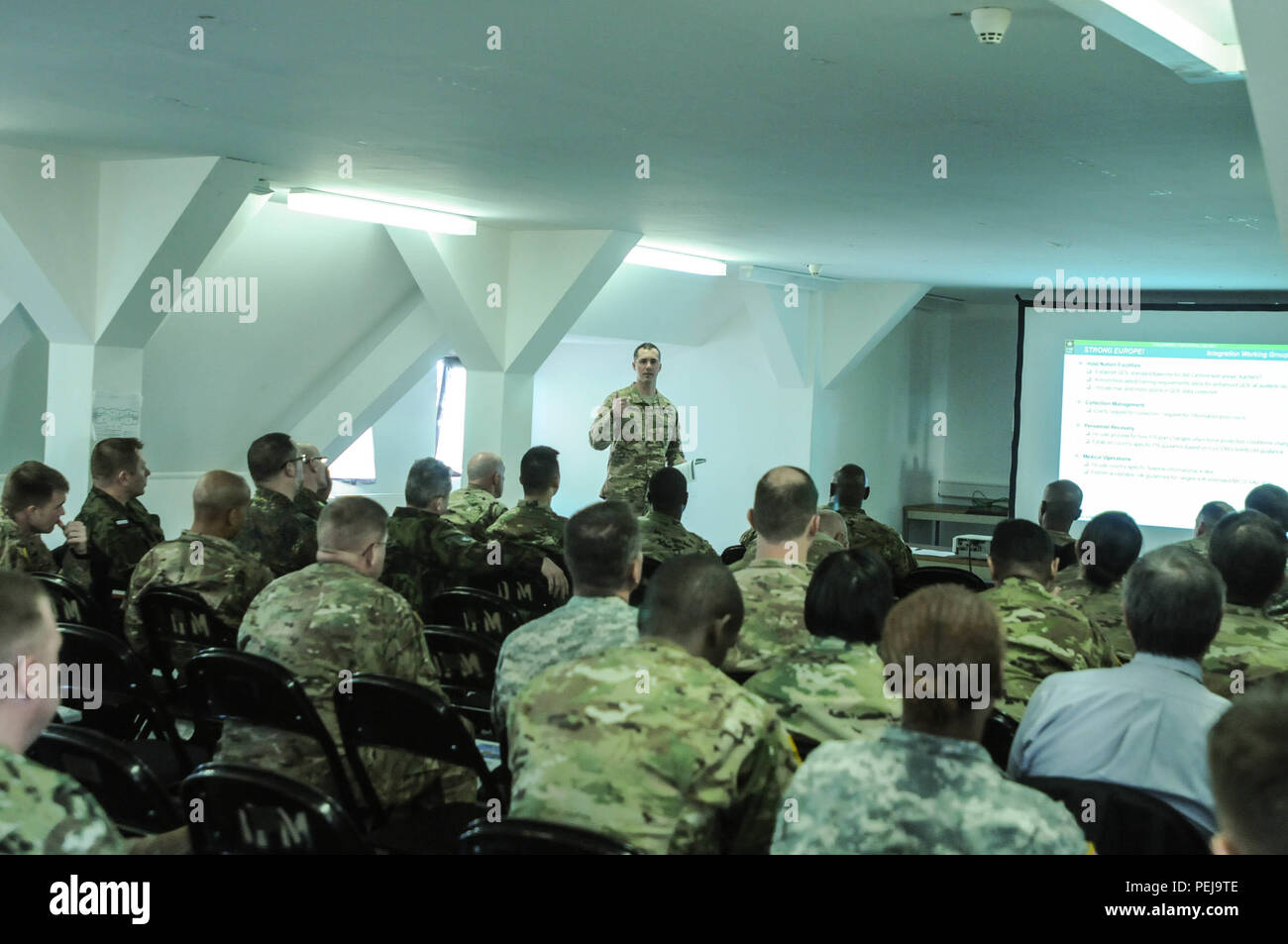 Maj. Jason Meier, assigned as the 4th Infantry Division mission Command element engineer, leads the integration working group discussion during an after action review in Baumholder, Germany, on Dec. 8, 2015. Representatives from units across Europe met for discussions and idea exchanges to build a standard operating procedure for the reception, staging, onward movement and integration process that transitions personnel and equipment arriving into the European theater supporting Atlantic Resolve. Stock Photo