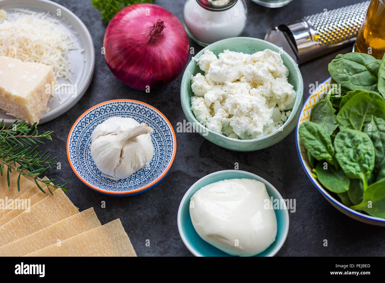 Ingredients for Vegetarian Spinach and Ricotta Lasagna, top view, dark background Stock Photo