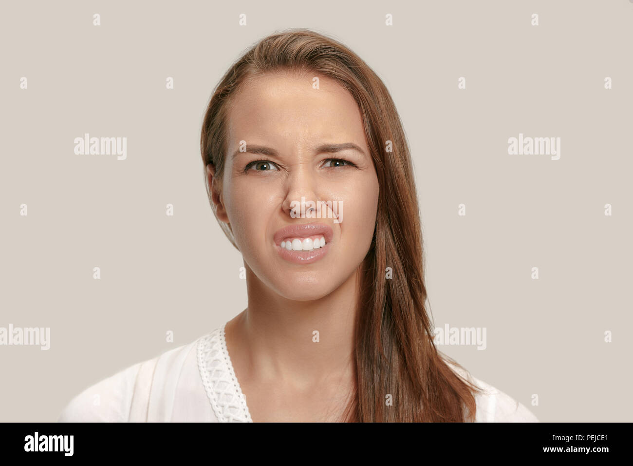 Annoyed irritated young feeling frustrated with something against white