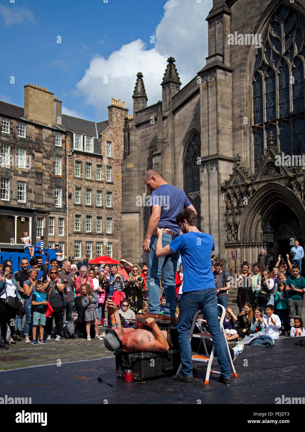 Edinburgh Fringe Festival, Royal Mile, Edinburgh, Street performer lies on bed of nails Scotland UK Stock Photo