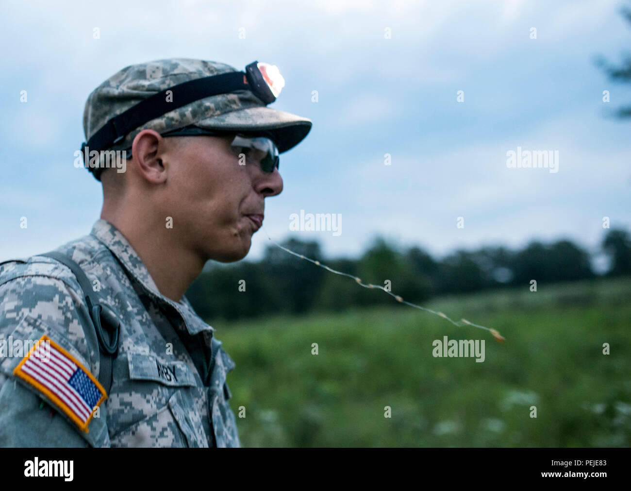 Pfc. Jorge Kirby, U.S. Army Reserve combat engineer with the 374th Engineer Company (Sapper), of Concord, Calif., spits while walking on a trail on a team-based land navigation course during the 2015 Sapper Stakes competition at Fort Chaffee, Ark., Aug. 30. The competition is designed to build teamwork, enhance combat engineering skills and promote leadership among the units. (U.S. Army photo by Master Sgt. Michel Sauret) Stock Photo