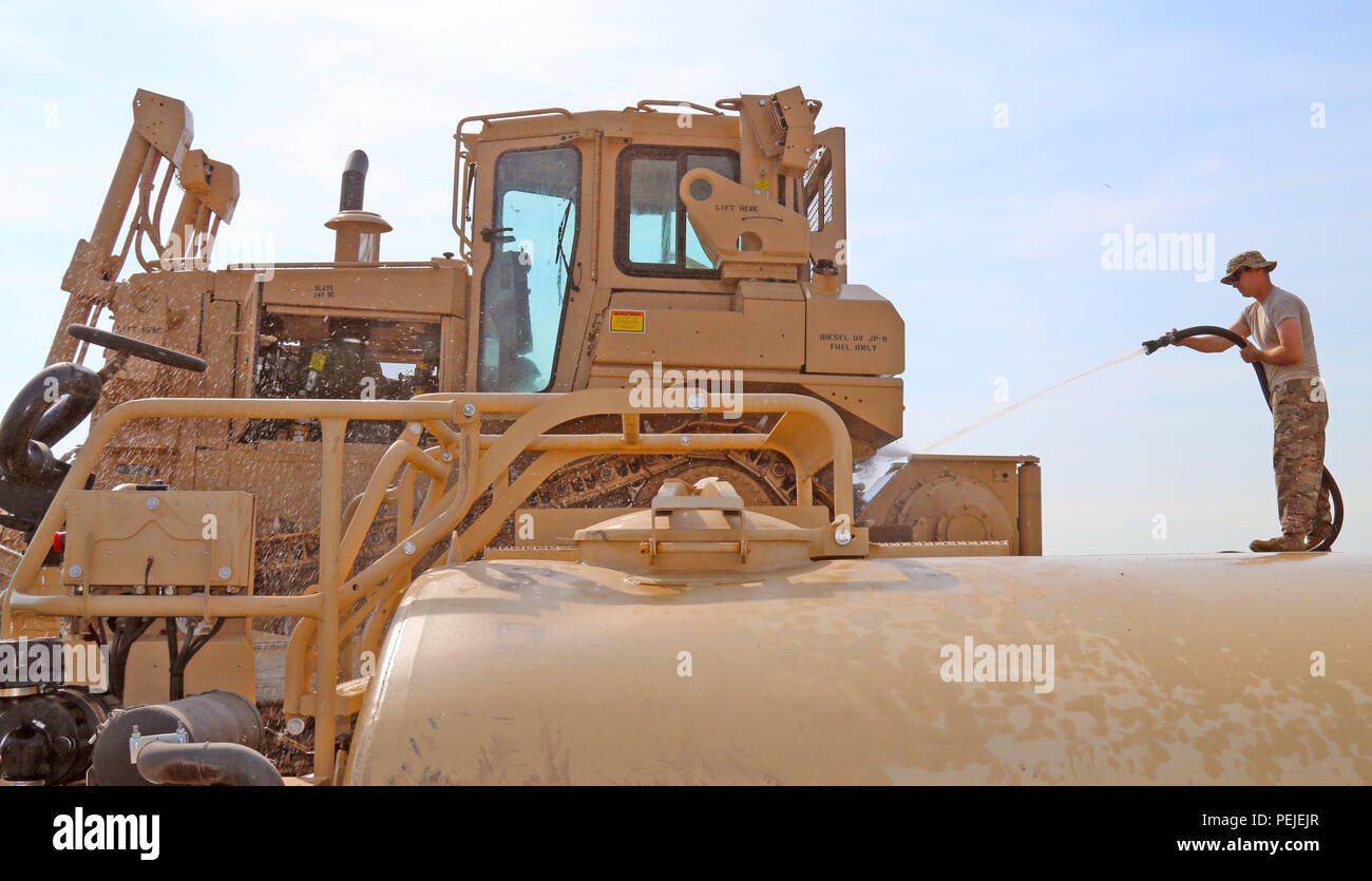 A U.S. Army mechanic from the 877th Engineer Battalion cleans a ...
