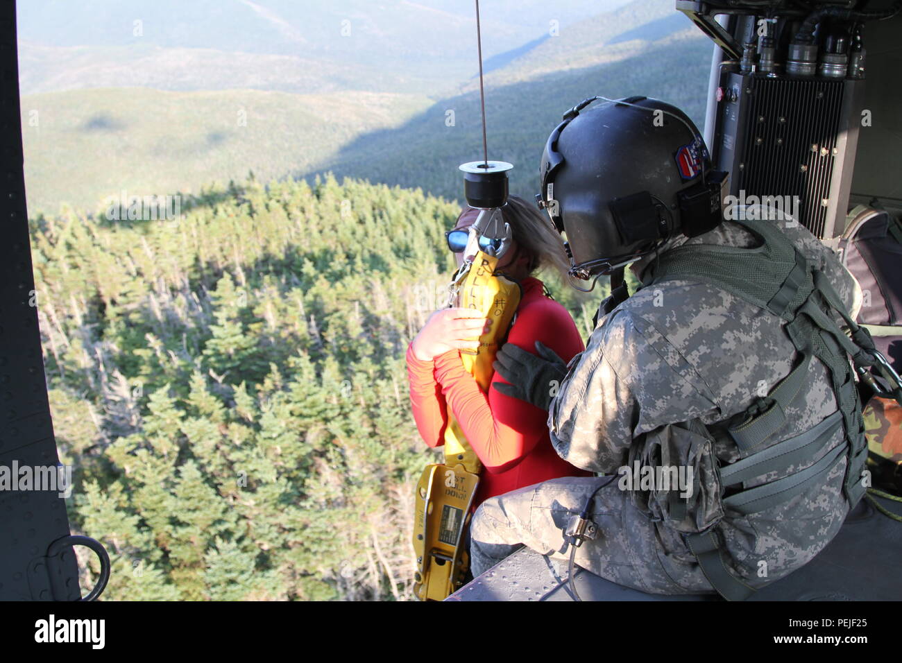 Sgt. Gavin Cafarellistrablizky, a Crew Chief with C company, 3/238th General Support Aviation Battalion, New Hampshire National Guard assists a hiker into a UH-60 Black Hawk during a rescue mission to Mount Garfield in Northwestern New Hampshire August 28. The hiker, Bethany Bourget of Bartlett, N.H., who was suffering an allergic reaction, was transported to a nearby ski resort parking lot where an ambulance waited. The New Hampshire Guard is regularly called upon to assist Fish and Game officials with Search and Rescue operations throughout the state. (Photo by Staff Sgt. Brian Gordon, 114th Stock Photo