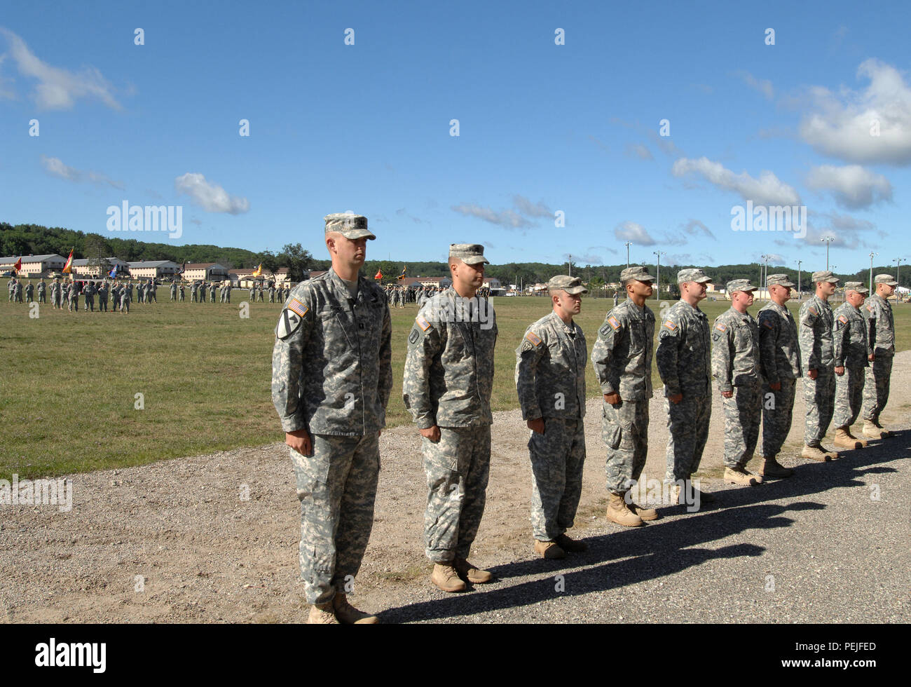 Michigan Army National Guard Soldiers receiving awards stand at attention at the start of the pass in review of troops and memorial ceremony at Camp Grayling Joint Maneuver Training Center, Grayling, Mich., Aug. 21, 2015. (U.S. Air National Guard photo by Master Sgt. Denice Rankin/Released) Stock Photo